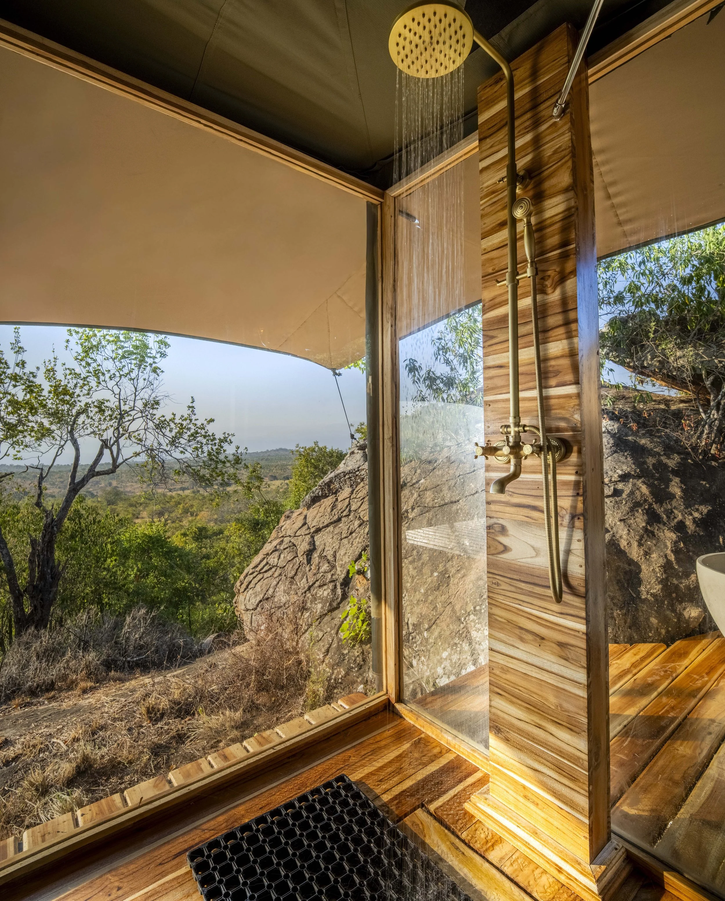 28. A glass-enclosed rain shower beside an ancient boulder.jpg