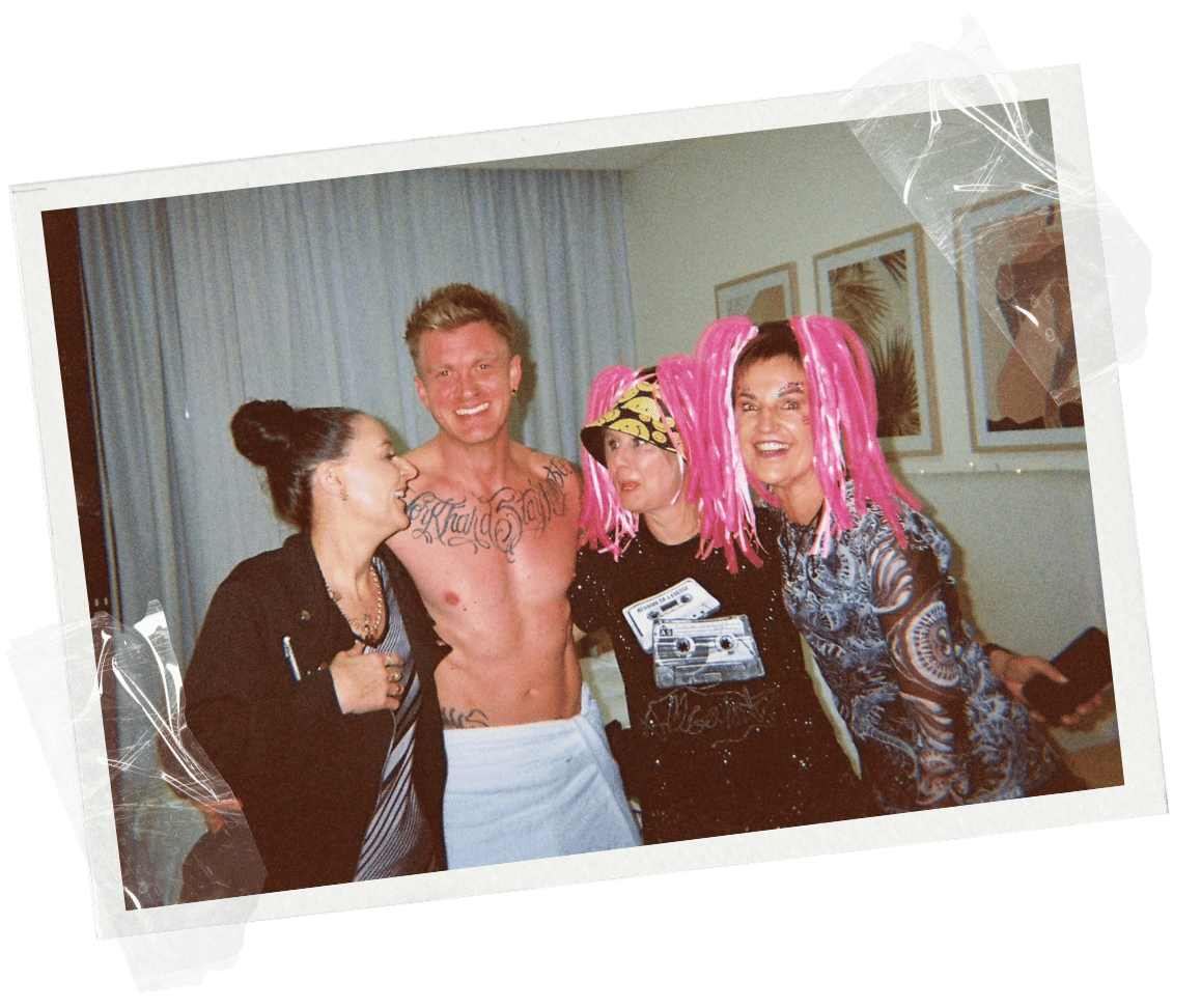 Women at a party taking a group photo with their blonde male stripper from sydney at an airbnb hens party in Central West New South Wales