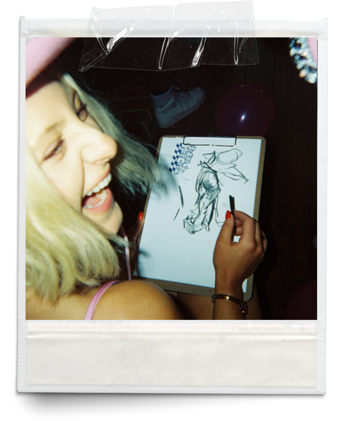Candid polaroid photo of a young lady sketching on a drawing pad at a hens life drawing class in Byron Bay.