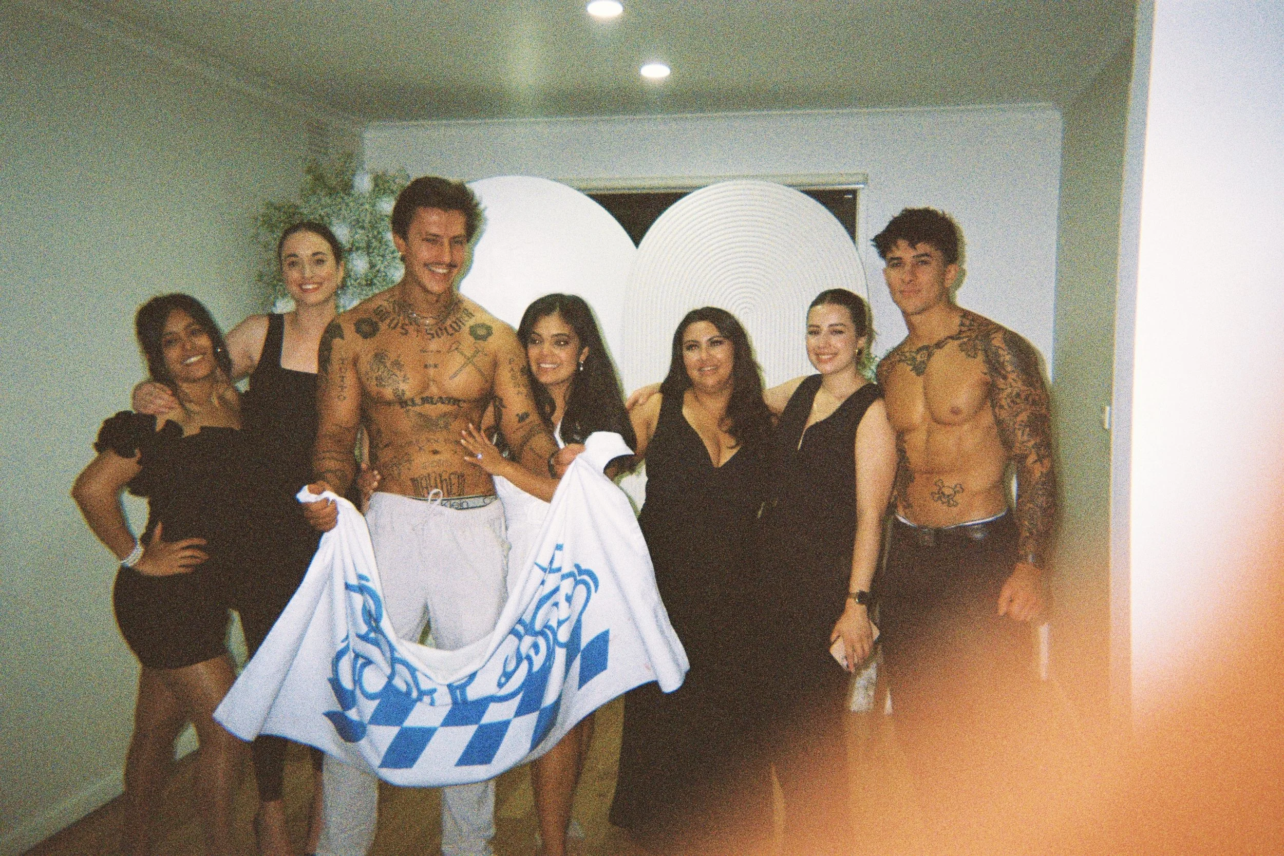 Topless waiters posing for a group photo with women at a hens party in Geelong