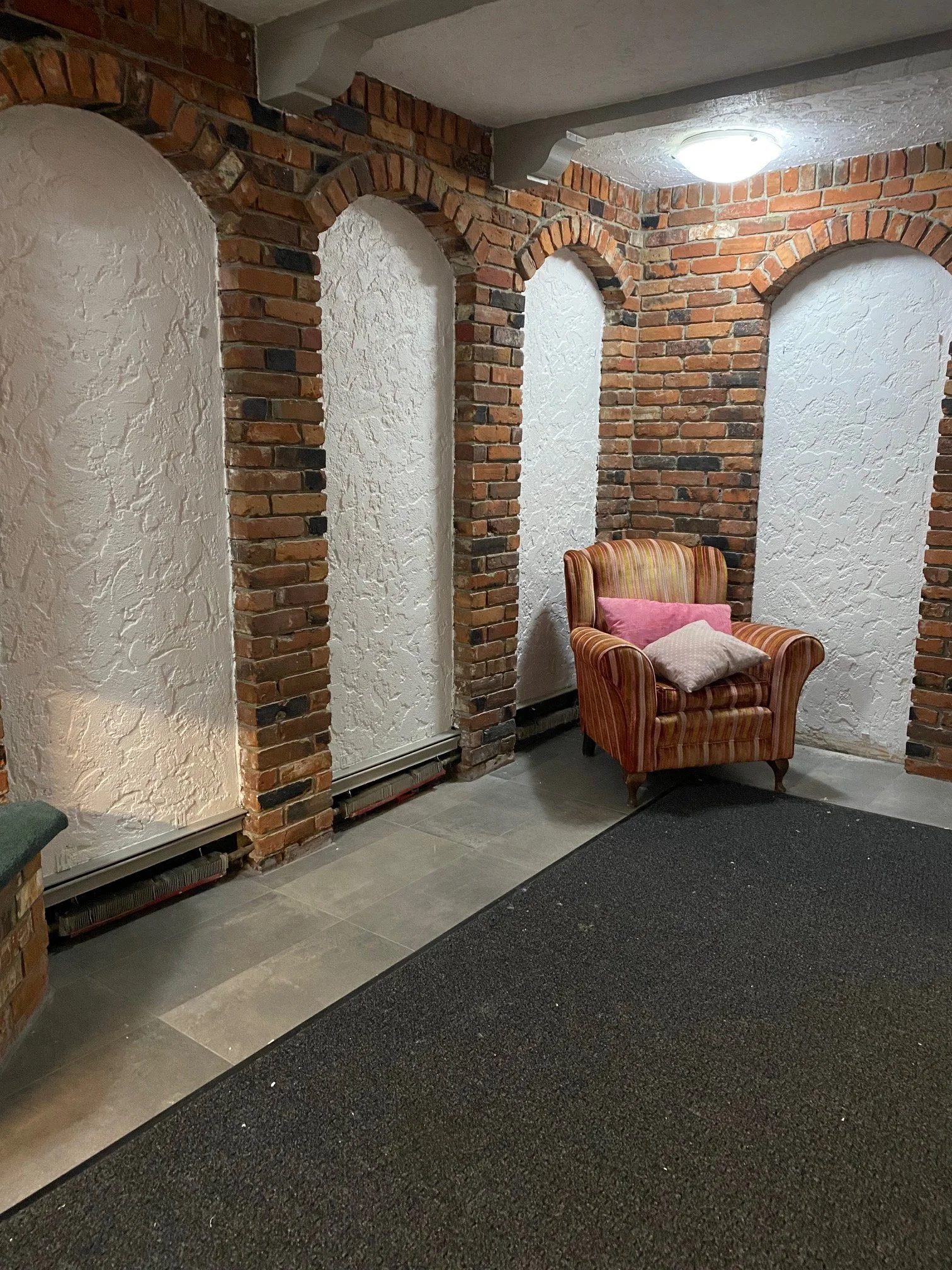 The freshly painted textured walls bring a clean, bright finish that beautifully highlights the natural brick archways. Careful attention to detail is seen in the crisp cut lines and smooth, even coverage throughout. The result is a polished, welcomi