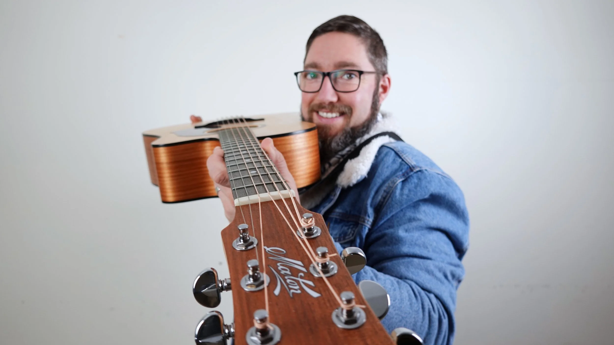 Adelaide musician, Jasper C Music, pointing acoustic guitar to camera.