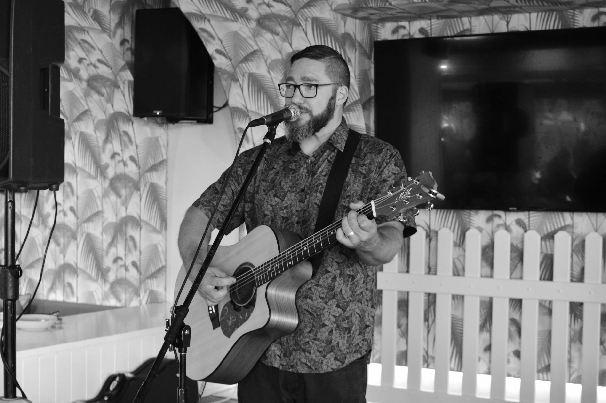 Adelaide musician, Jasper C Music, showing acoustic sets. Black and white image of Jasper singing and playing guitar.