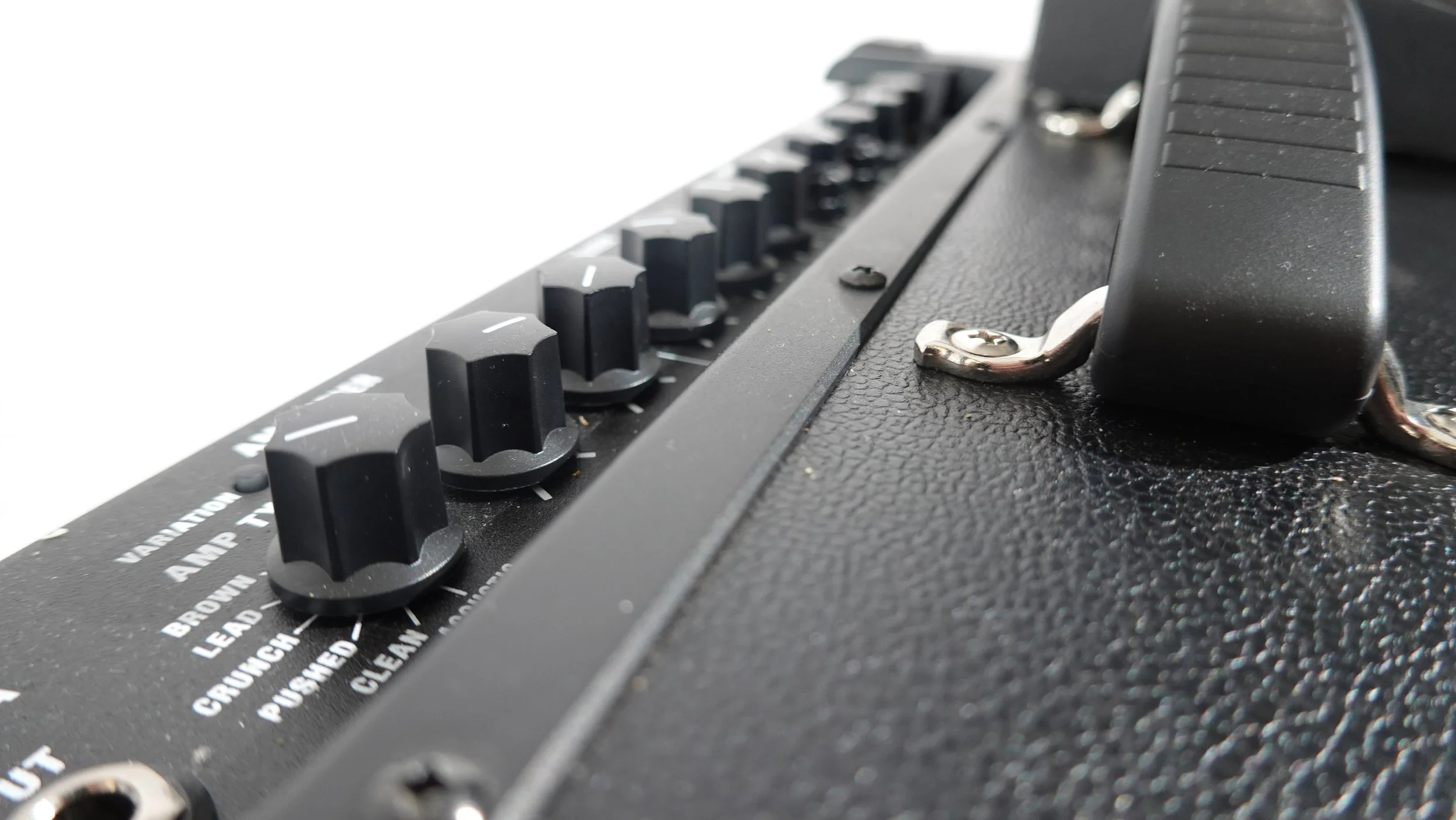Close-up of control knobs and handle on a black guitar amplifier