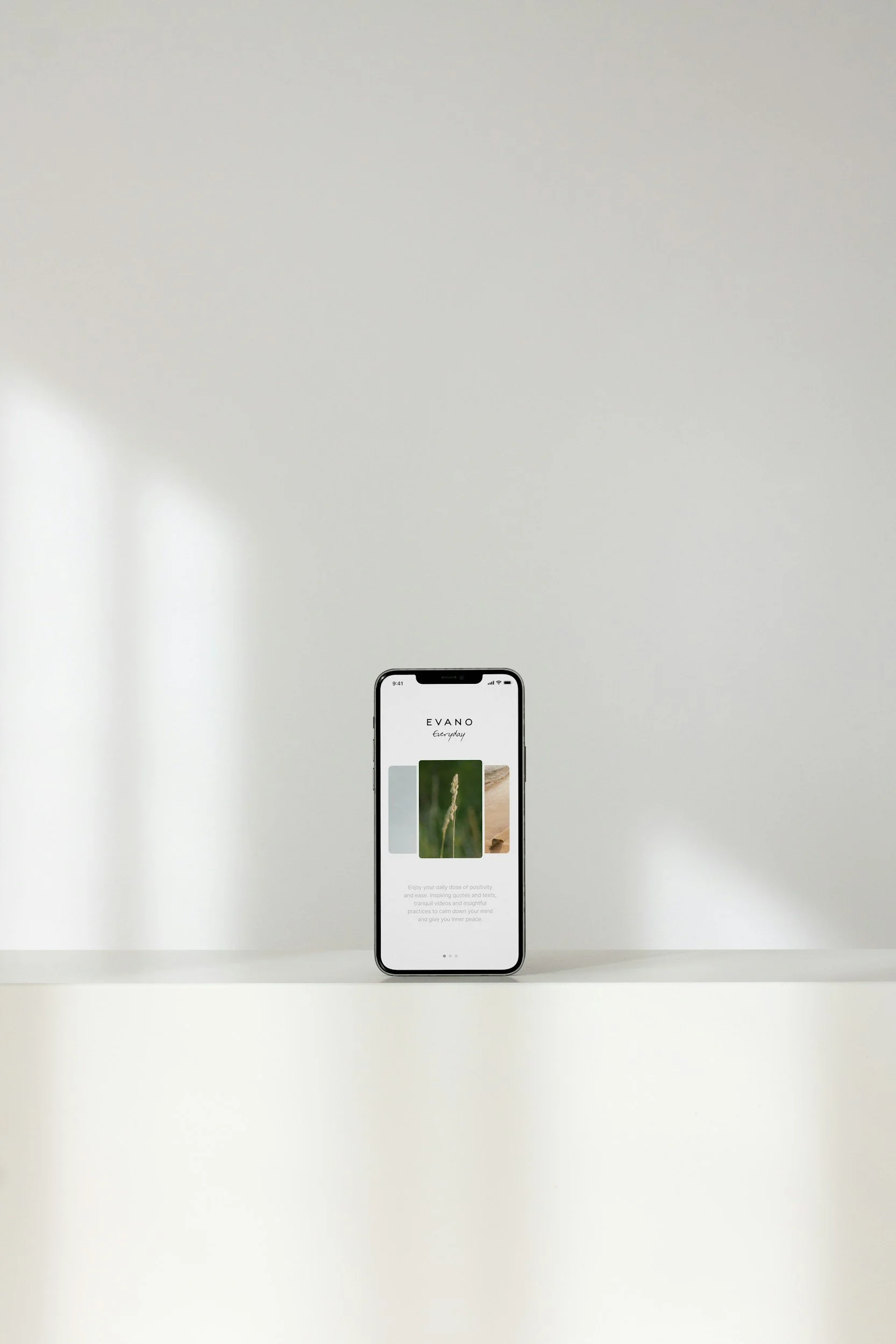 Smartphone displaying the EVANO app on a minimalist white surface with a plain light-colored background.