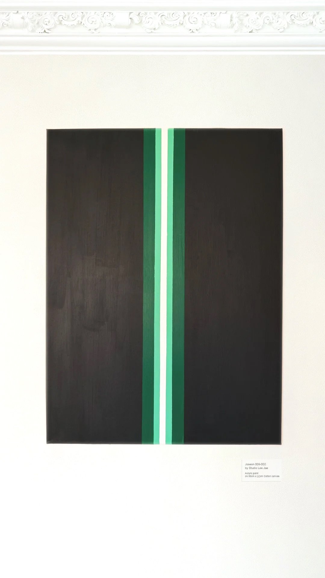 Abstract painting with vertical green and white stripes on a black background, displayed on a white wall.