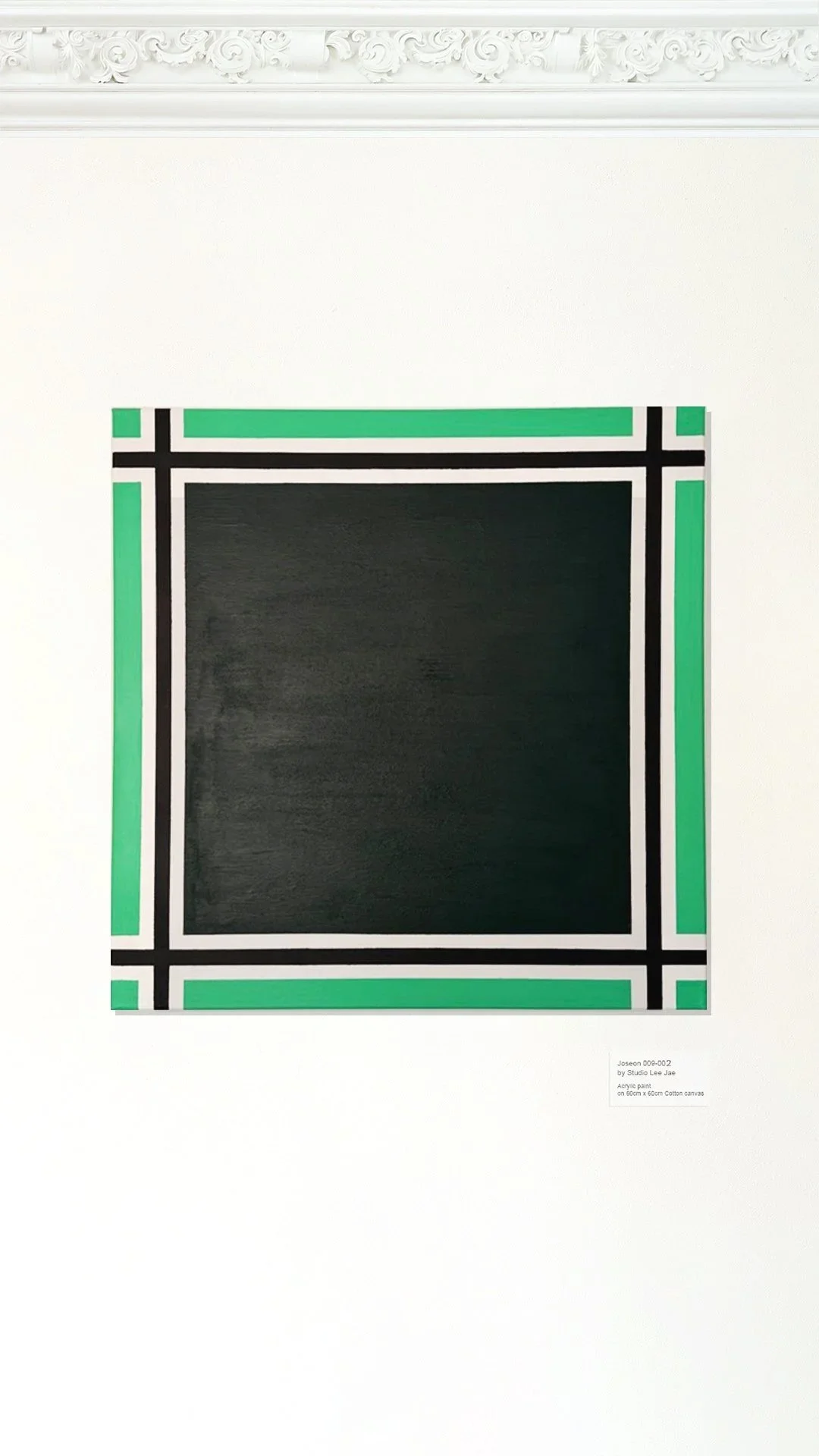An artwork titled 'Joseon 009-002' by Studio Lee Jae, consisting of acrylic paint on cotton canvas, featuring a black square surrounded by a border of green and black lines, mounted on a white wall.