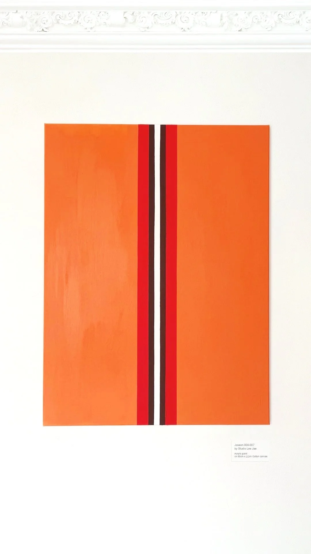 A rectangular abstract painting with orange background and black, red, and white vertical stripes on a white gallery wall.
