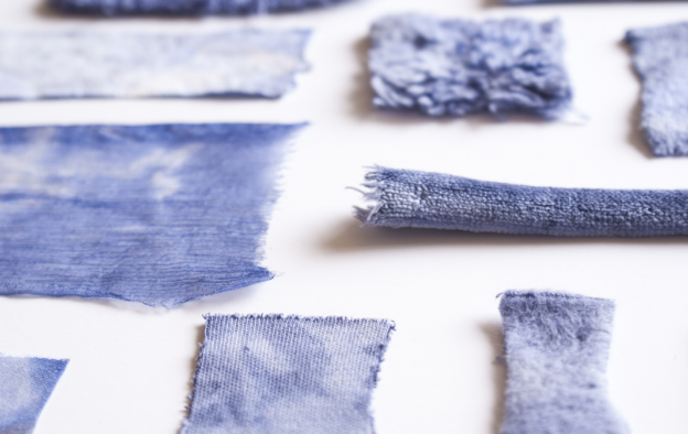 Various swatches of blue denim fabric on a white background.