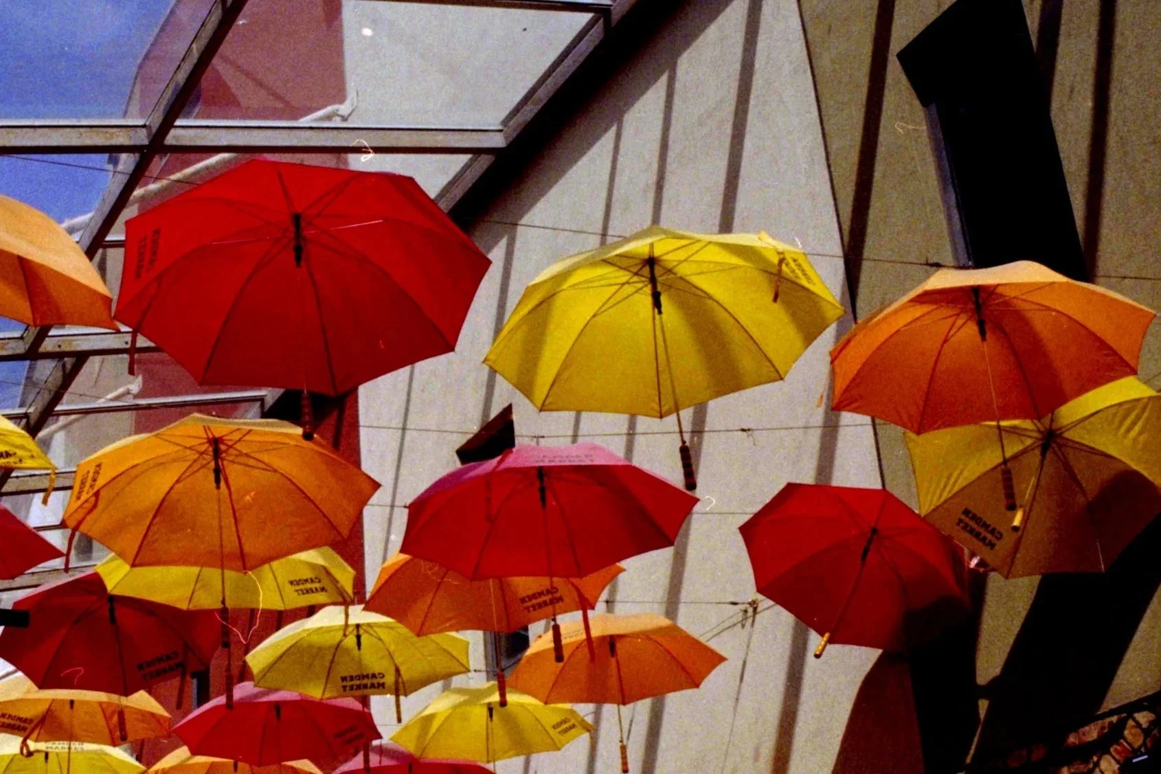 Colorful umbrellas hanging upside down on a ceiling in an indoor space.