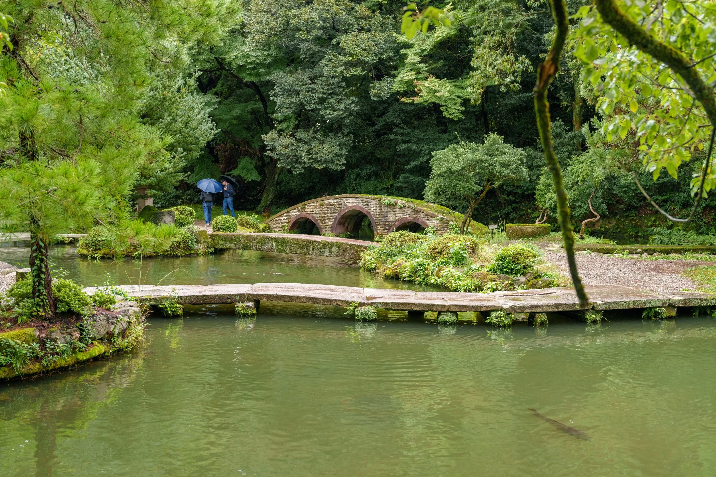 Pont de pierre au-dessus de l'étang du jardin Kenrokuen à Kanazawa