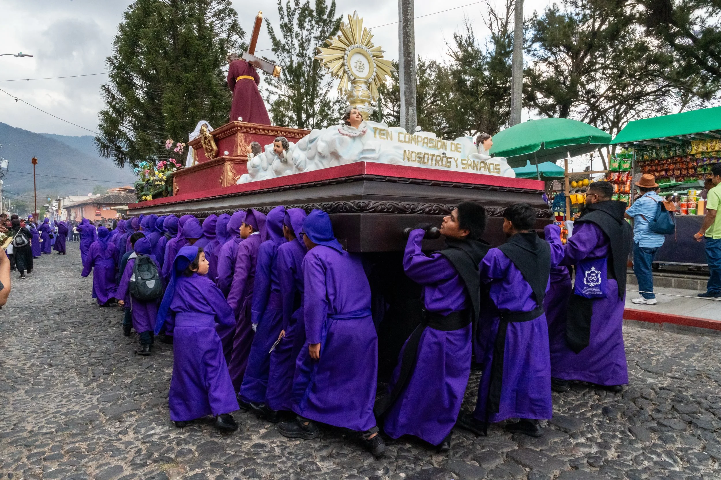 Jeunes porteurs en violet sous l'anda rouge à l'ostensoir doré