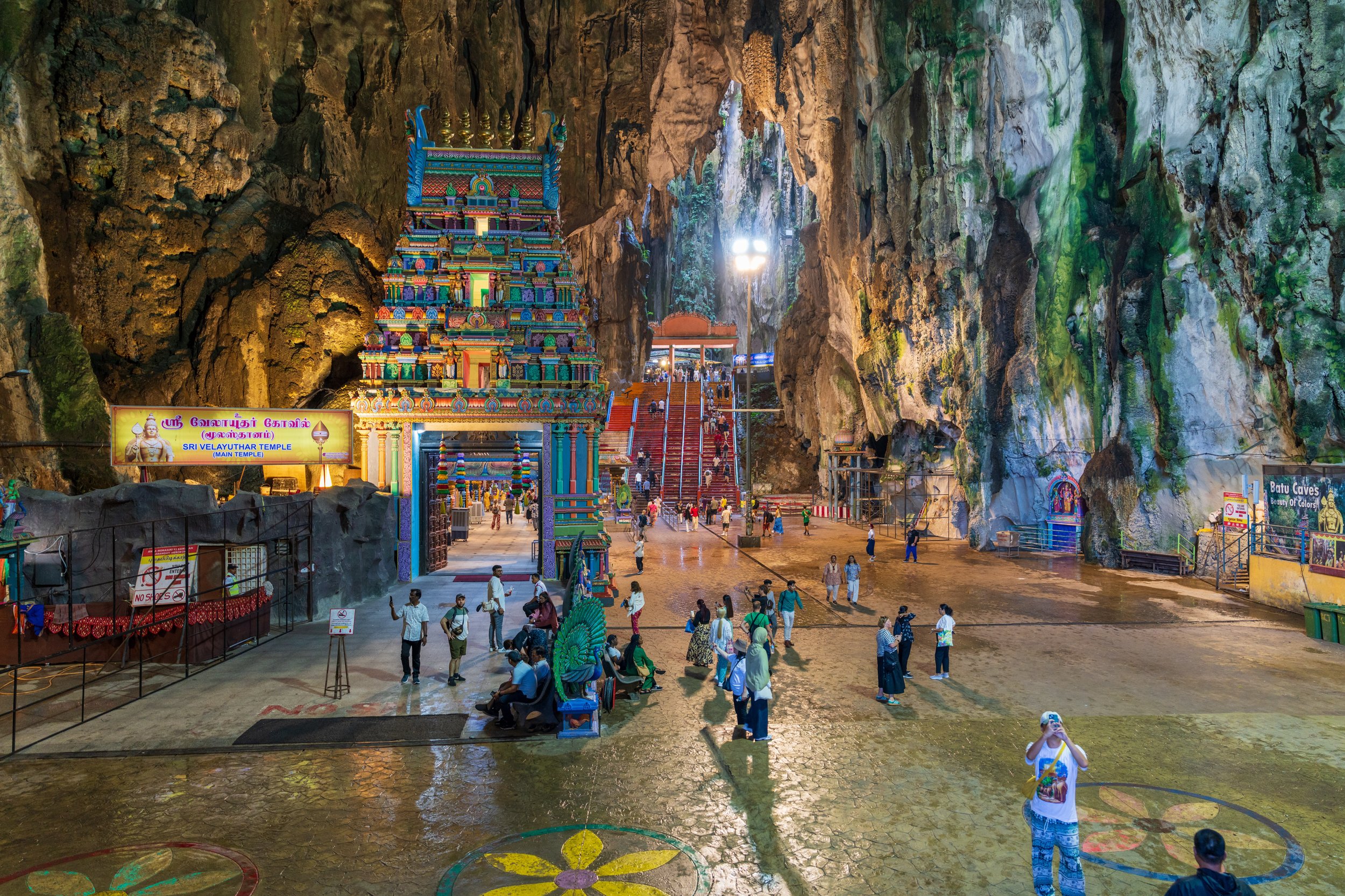 Intérieur de la grotte principale de Batu Caves avec le temple hindou coloré et des pèlerins