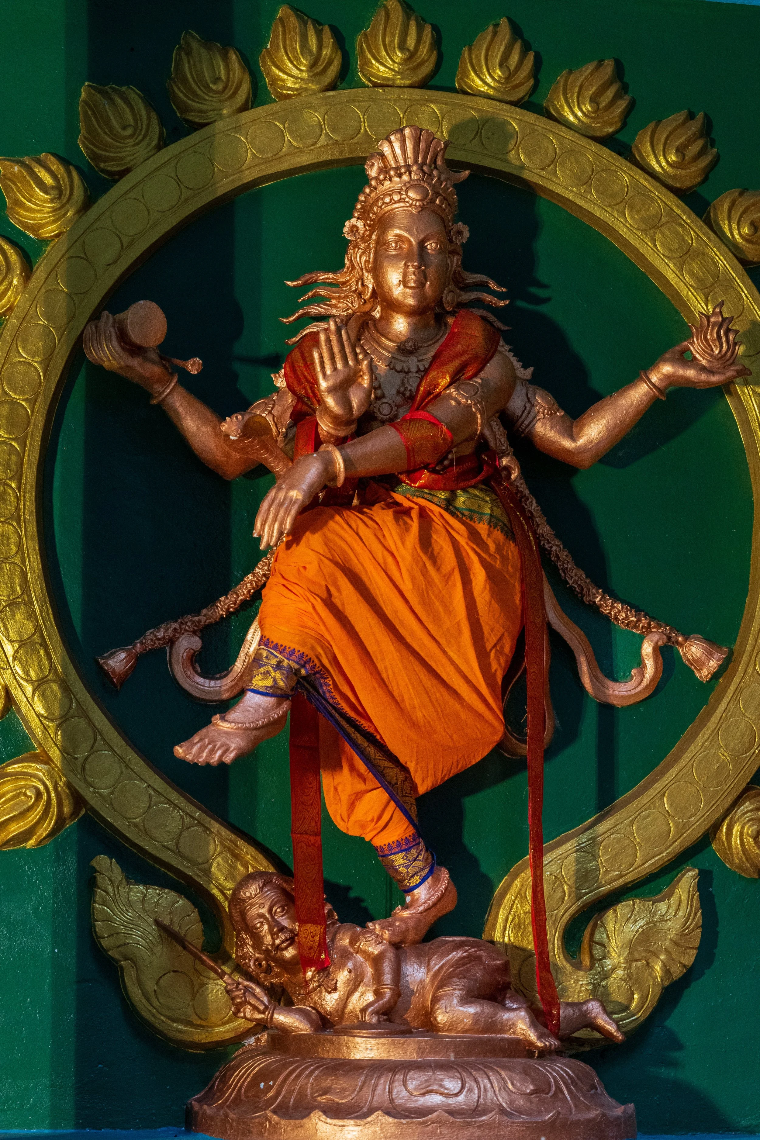 Statue hindoue multi-bras colorée dans une niche du temple de Batu Caves