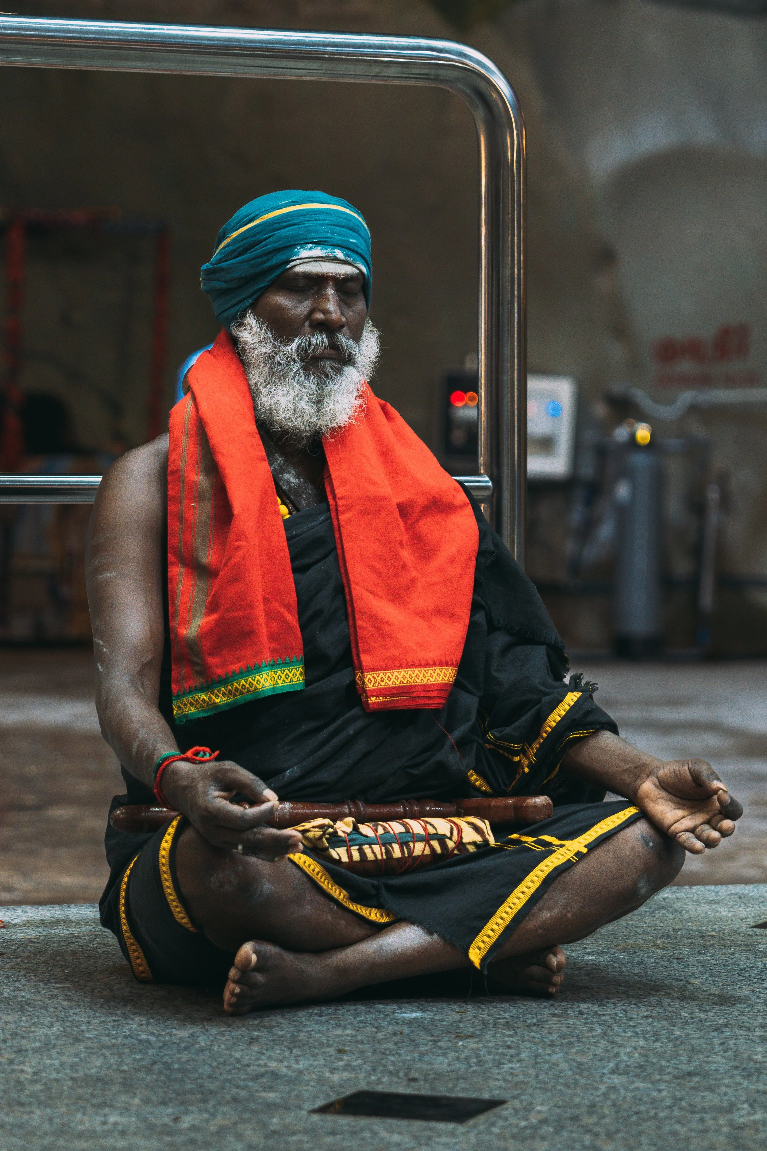 Portrait d'un homme en prière au sanctuaire de Batu Caves, turban et écharpe orange traditionnels