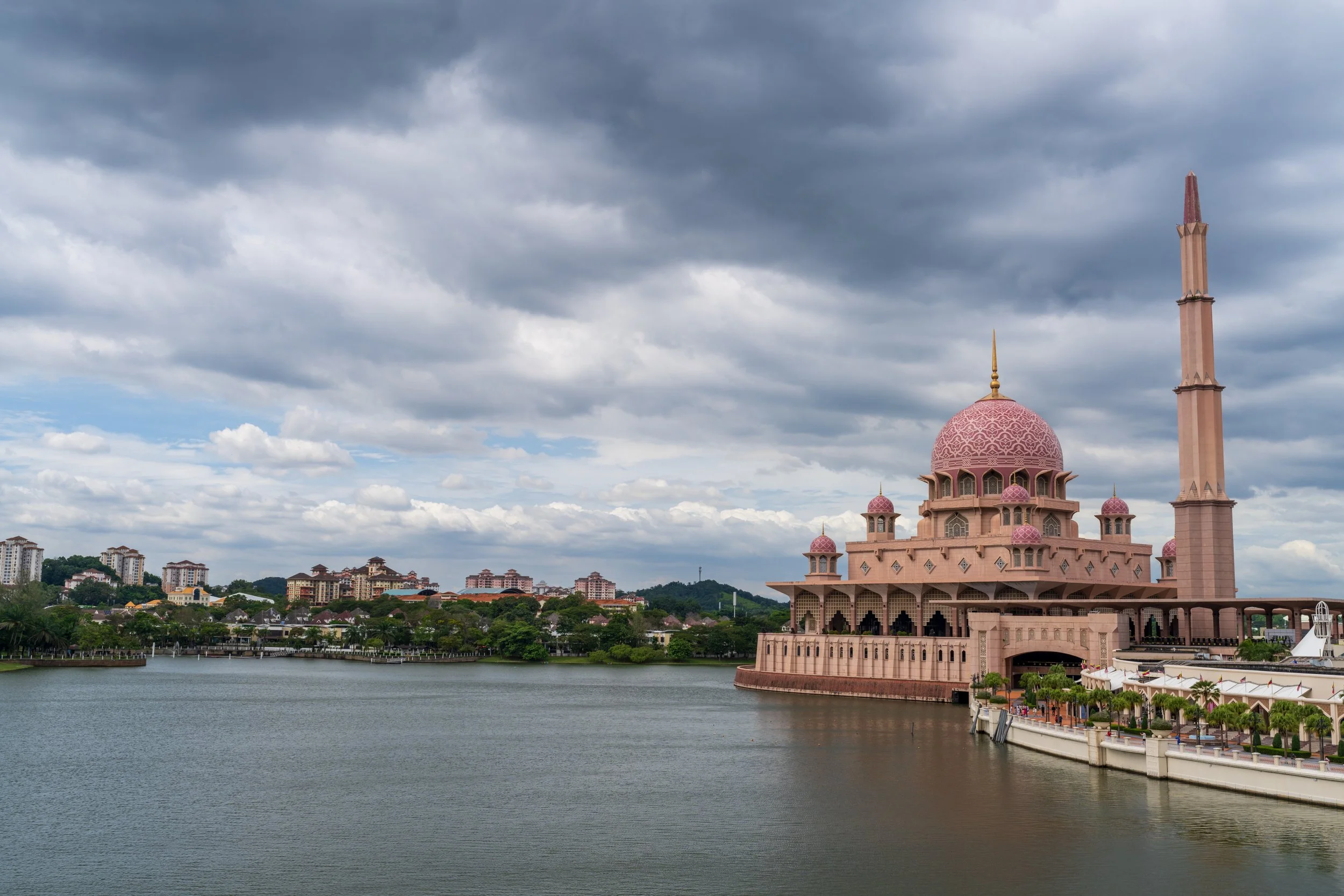 La mosquée Putra, rose et posée sur le lac artificiel de Putrajaya, sous un ciel nuageux