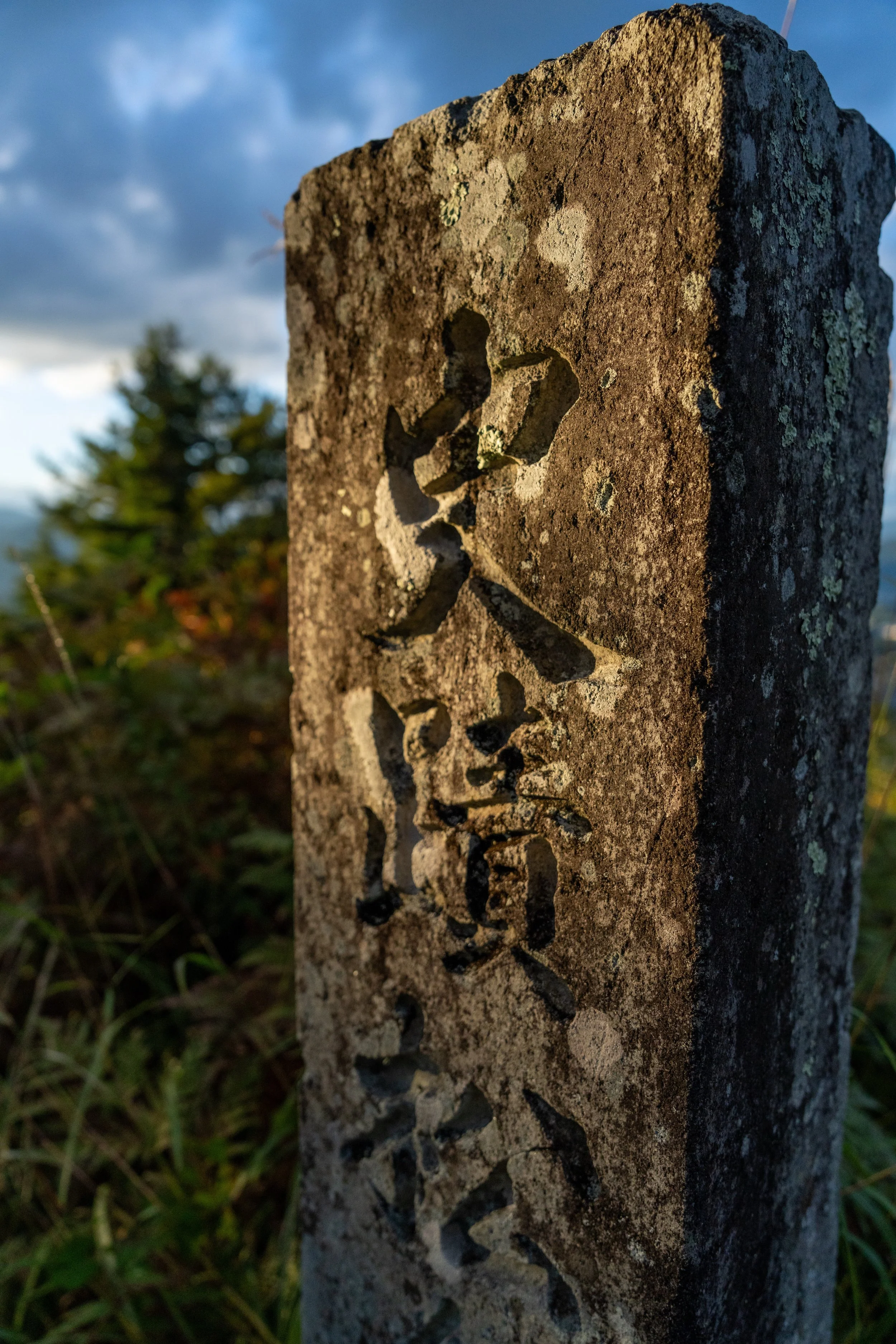 Stèle de pierre gravée de kanji marquant le site historique du château de Takayama