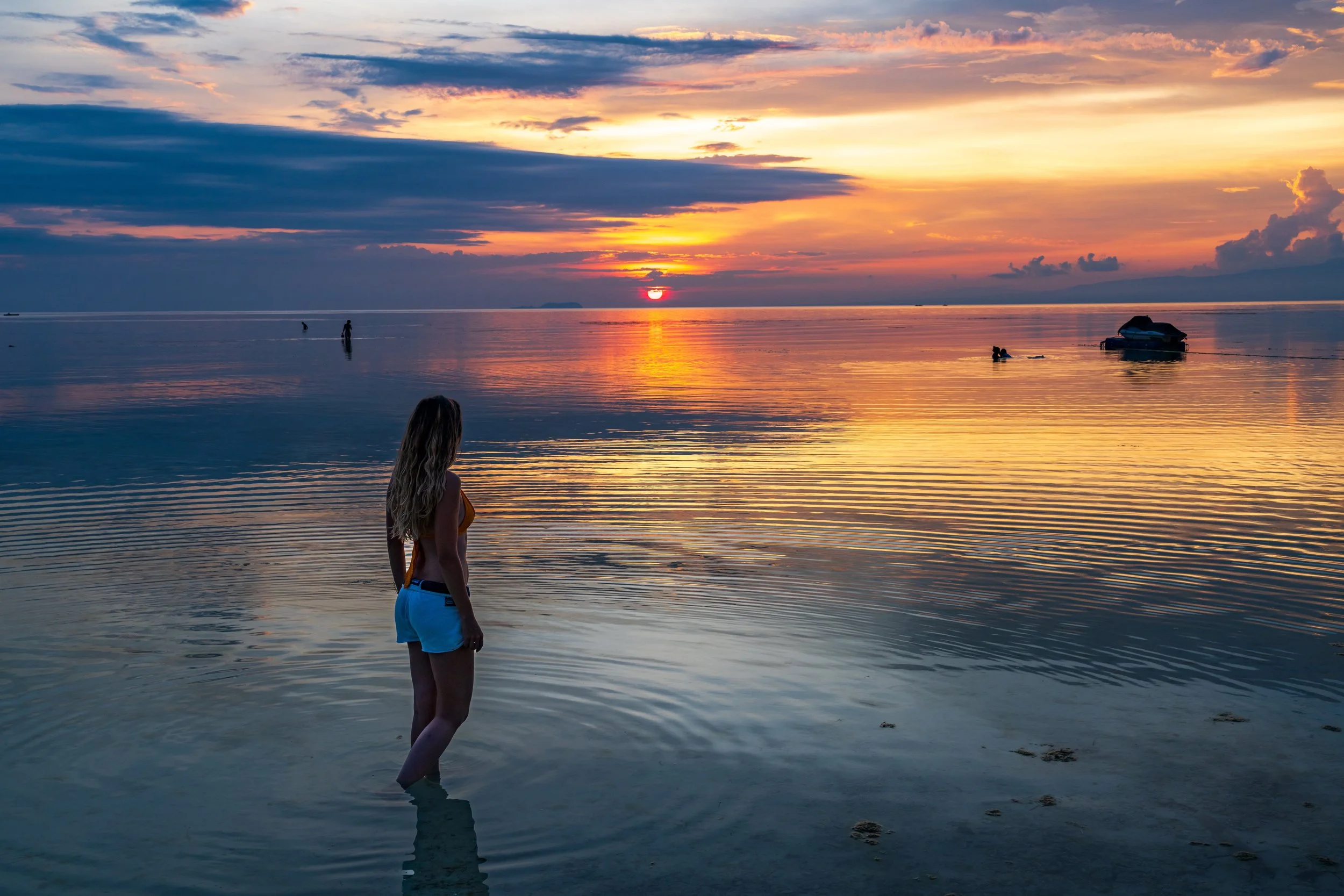 Voyageuse contemplant le coucher de soleil sur une plage de Siquijor aux Philippines