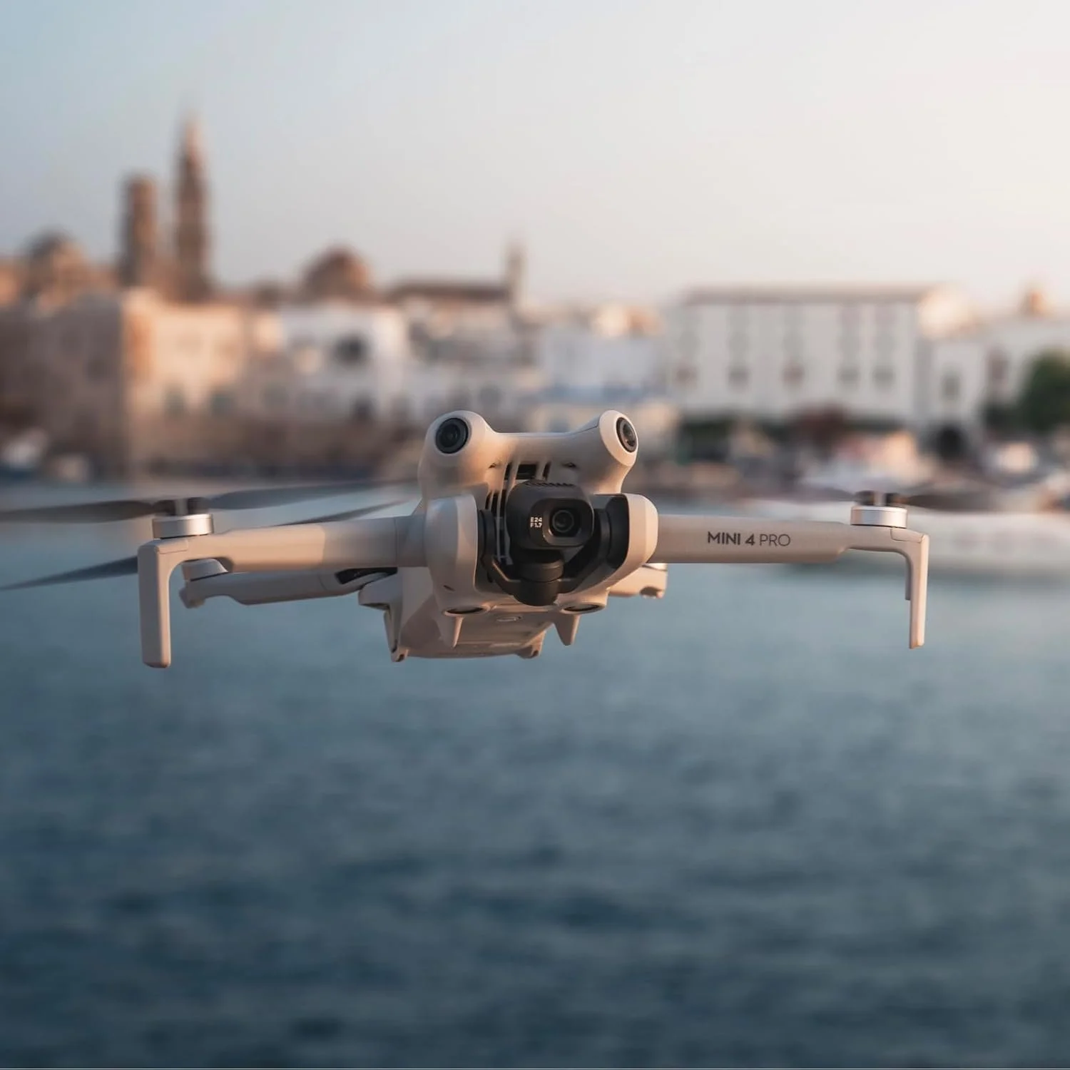 Drone DJI Mini 4 Pro en vol au-dessus d'un village côtier