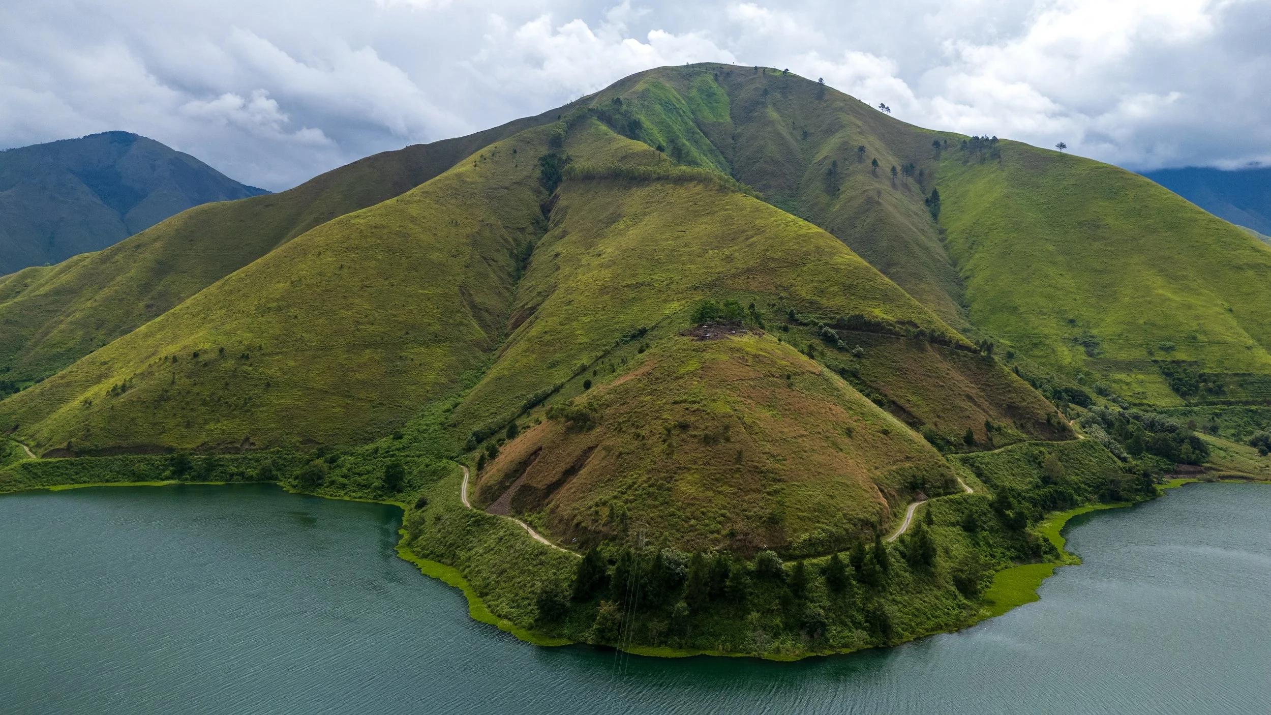 Collines verdoyantes de l'île de Samosir plongeant dans le lac Toba à Sumatra