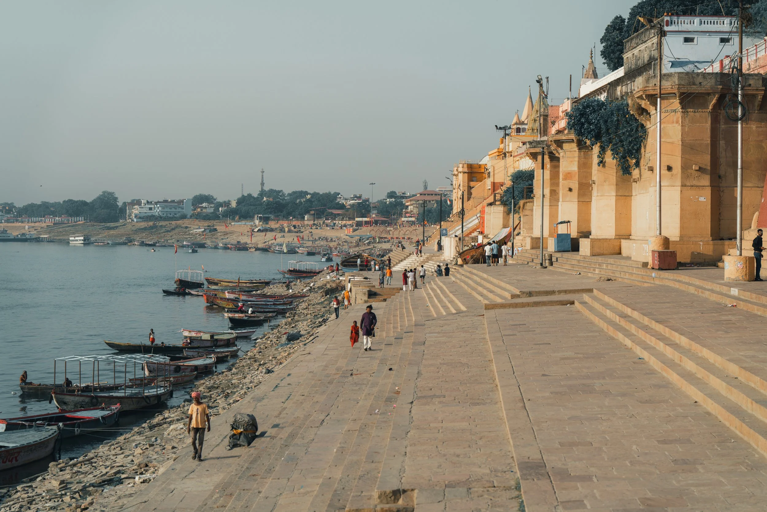 Escaliers des ghats de Varanasi au lever du soleil avec barques sur le Gange