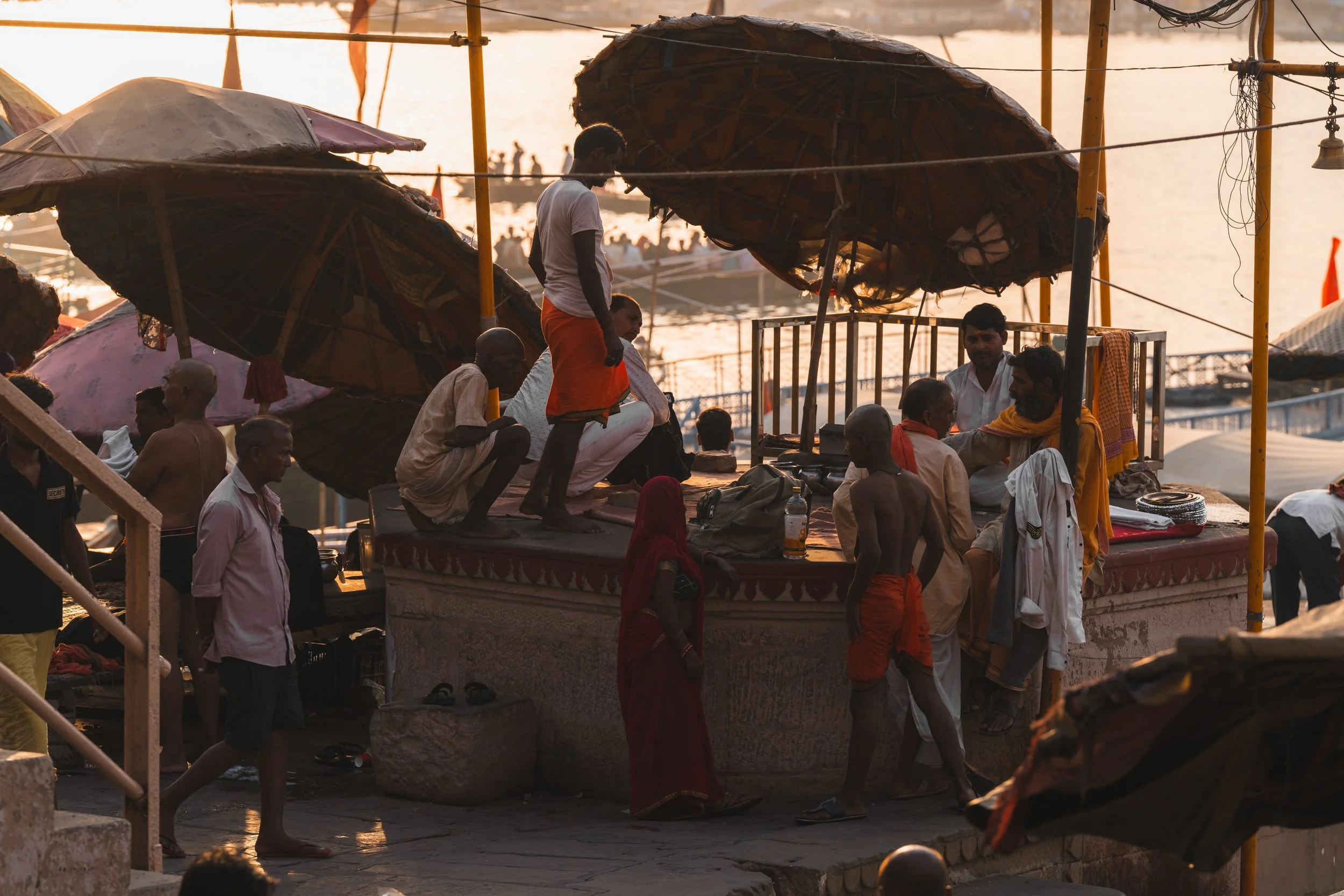 Pratiquants et ombrelles de paille sur un ghat de Varanasi en plein soleil