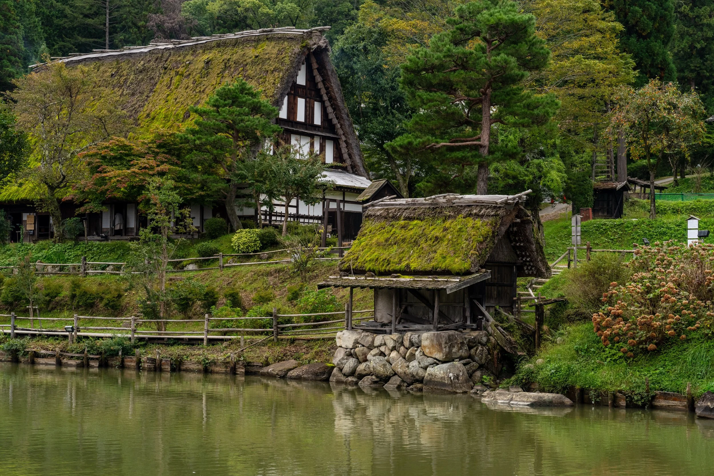 Fermes traditionnelles au toit de chaume au bord d'un étang à Hida no Sato