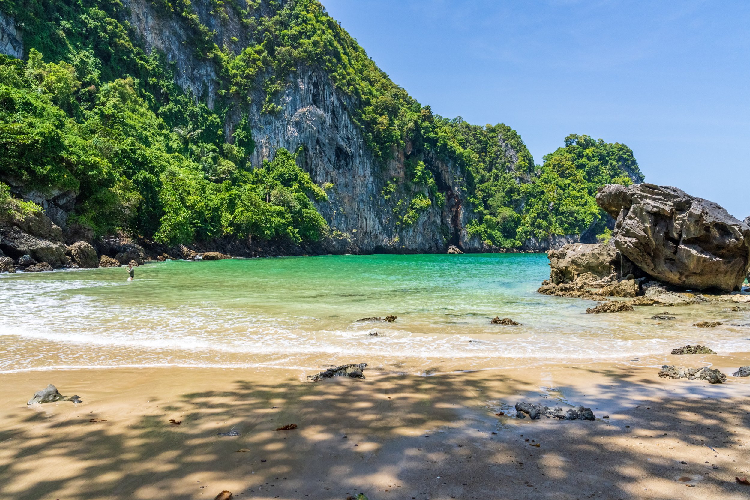 Plage cachée de la grotte d'Émeraude entourée de falaises calcaires à Koh Mook