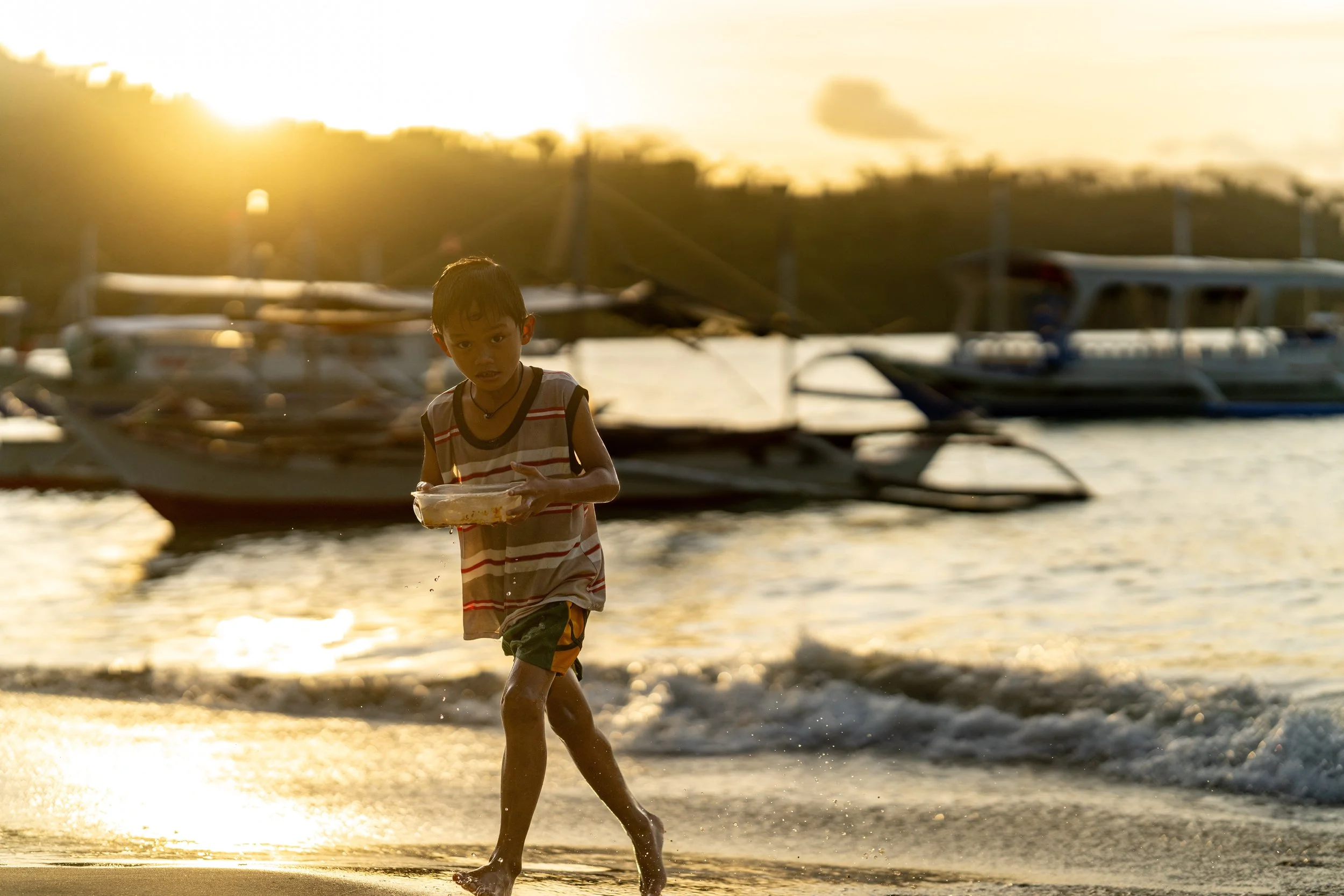 Enfant marchant sur la plage de Port Barton dans la lumière du soir
