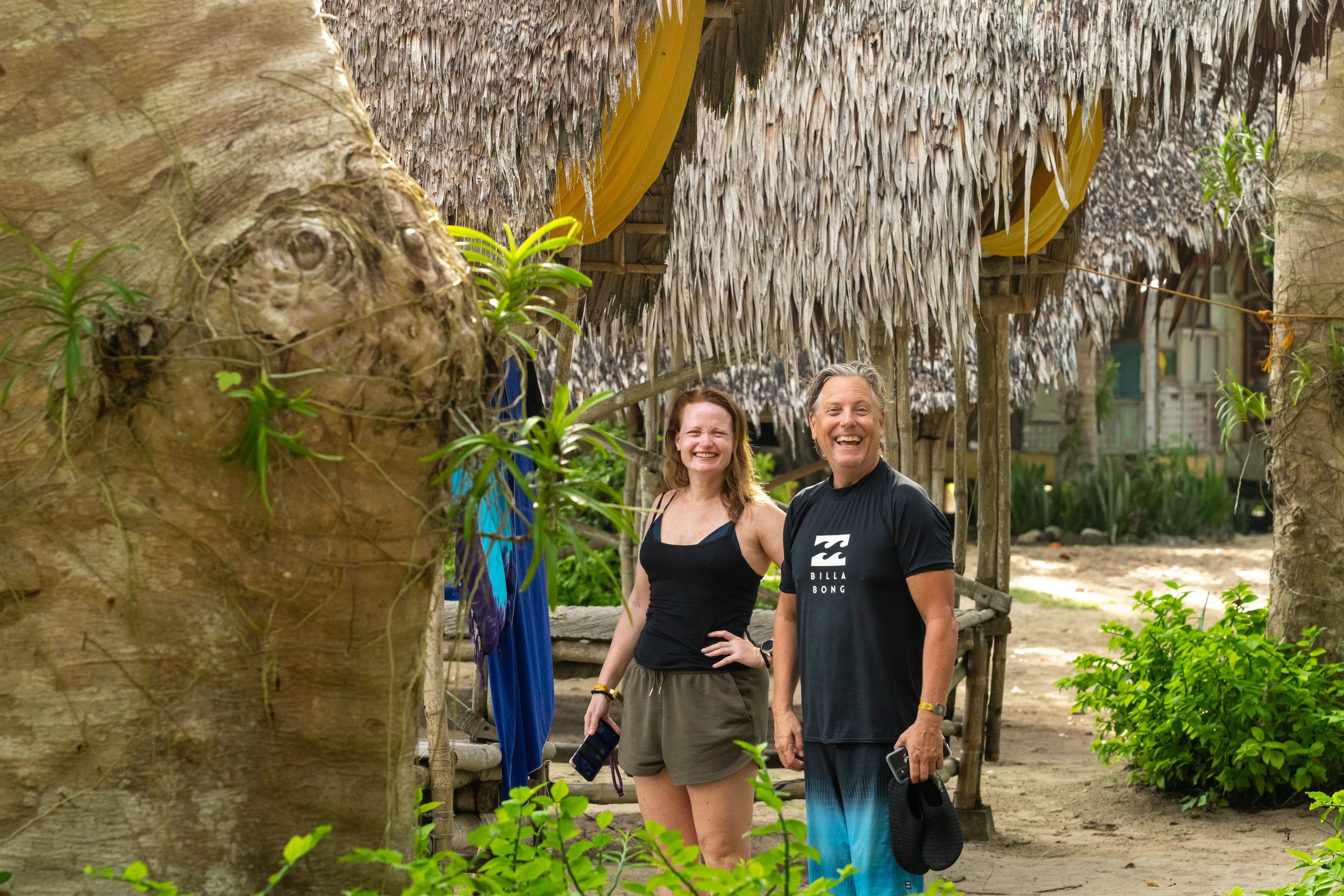 Voyageurs devant une hutte au toit de chaume d'un camp de base de Tao Philippines