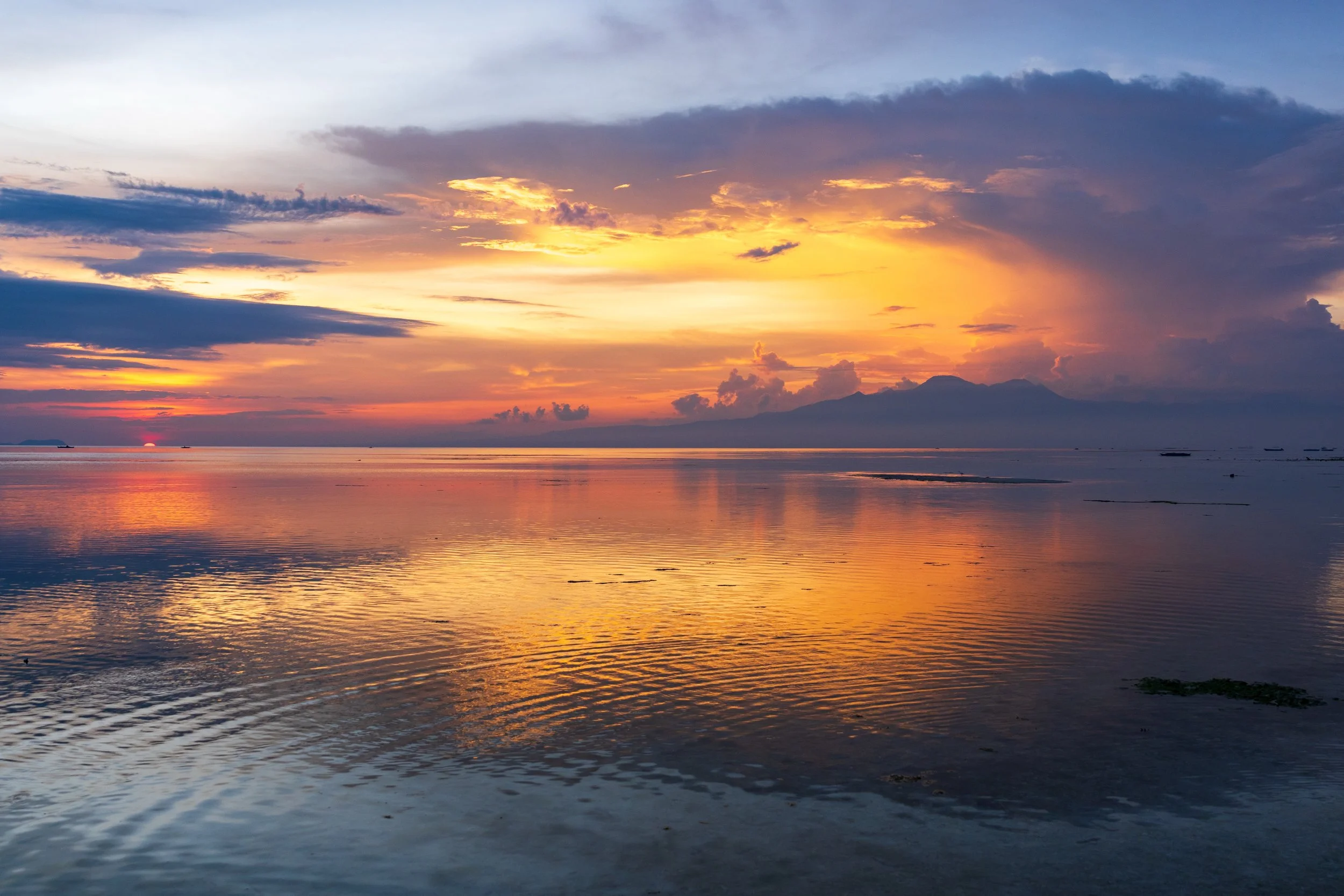 Coucher de soleil orangé se reflétant sur la mer à marée basse à Siquijor