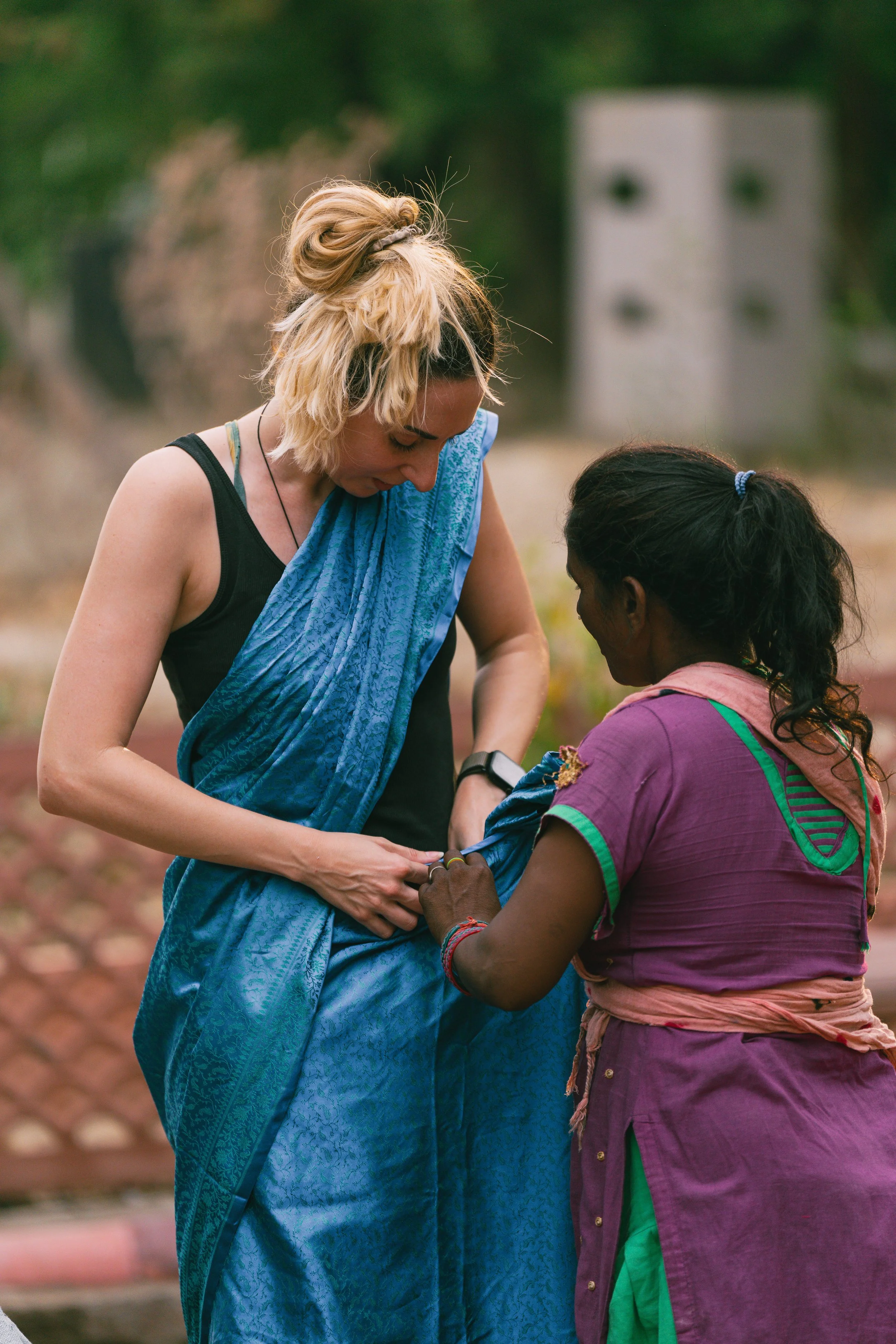 Femme indienne aidant une voyageuse à dràper un sari à Agra