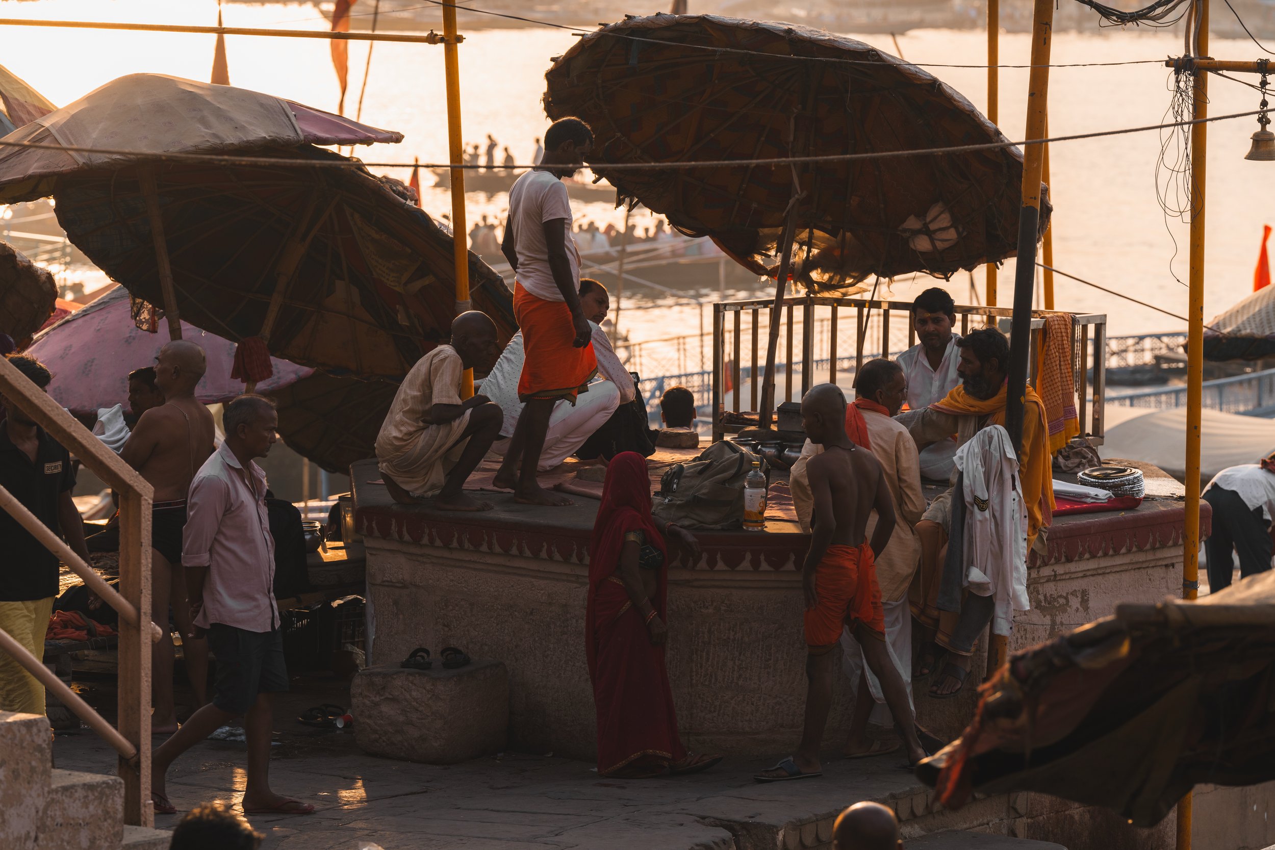 Pèlerins réunis sous les grandes ombrelles de paille d'un ghat de Varanasi