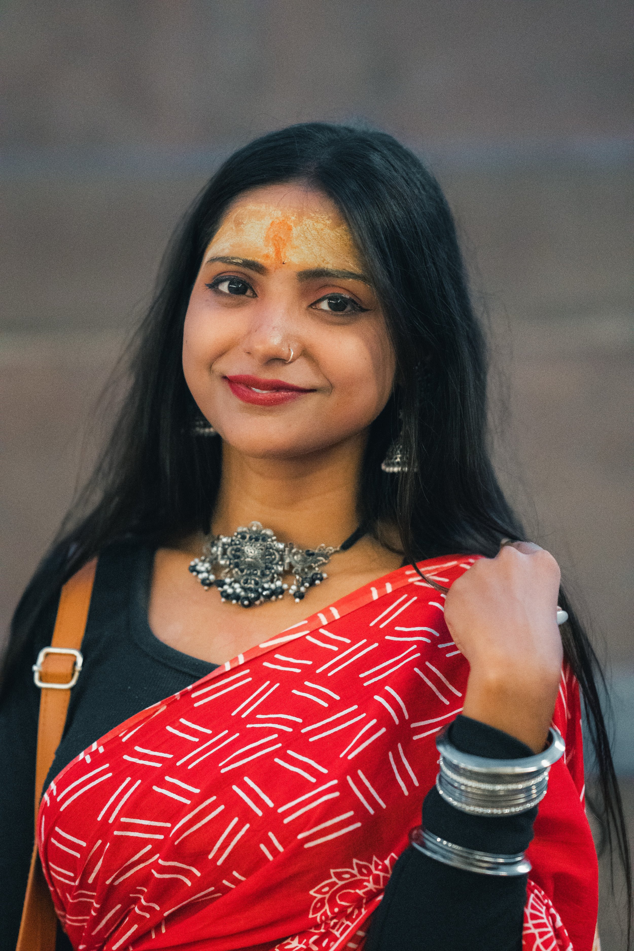 Femme portant un tilak orange et un sari rouge lors d'une fête à Varanasi