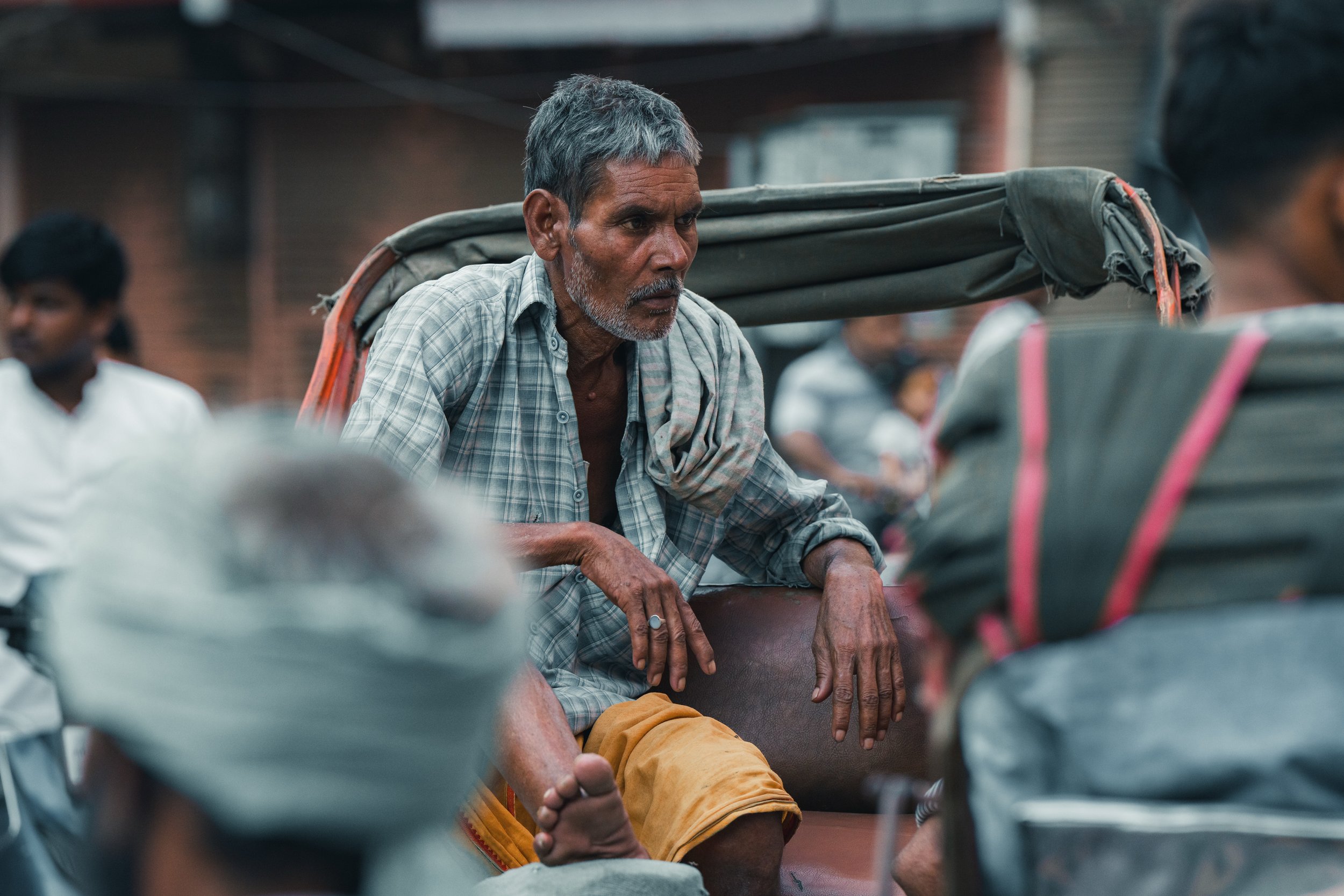 Conducteur de rickshaw attendant ses clients dans une rue de Varanasi en Inde