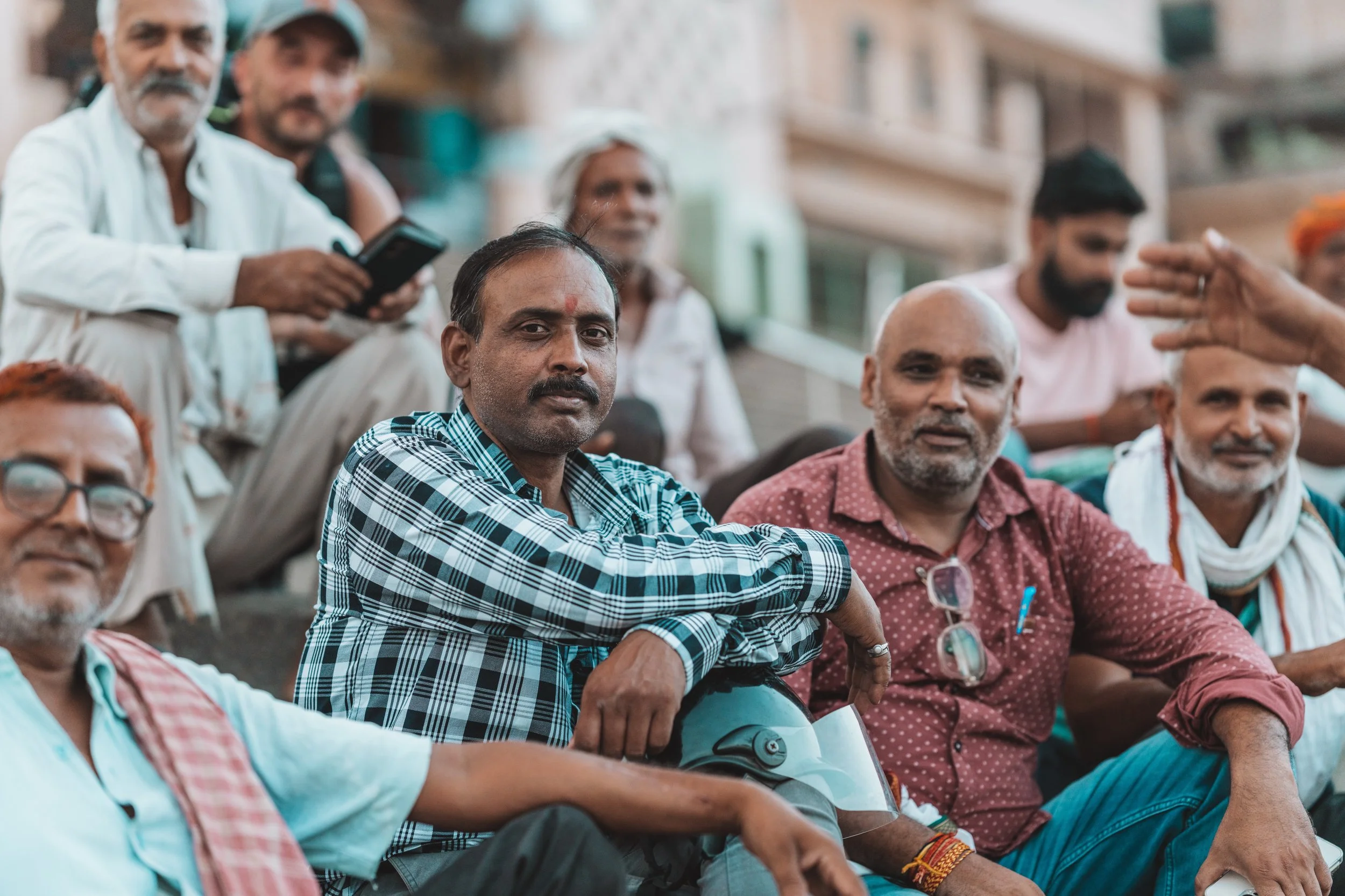 Hommes discutant assis sur les marches d'un ghat de Varanasi en Inde