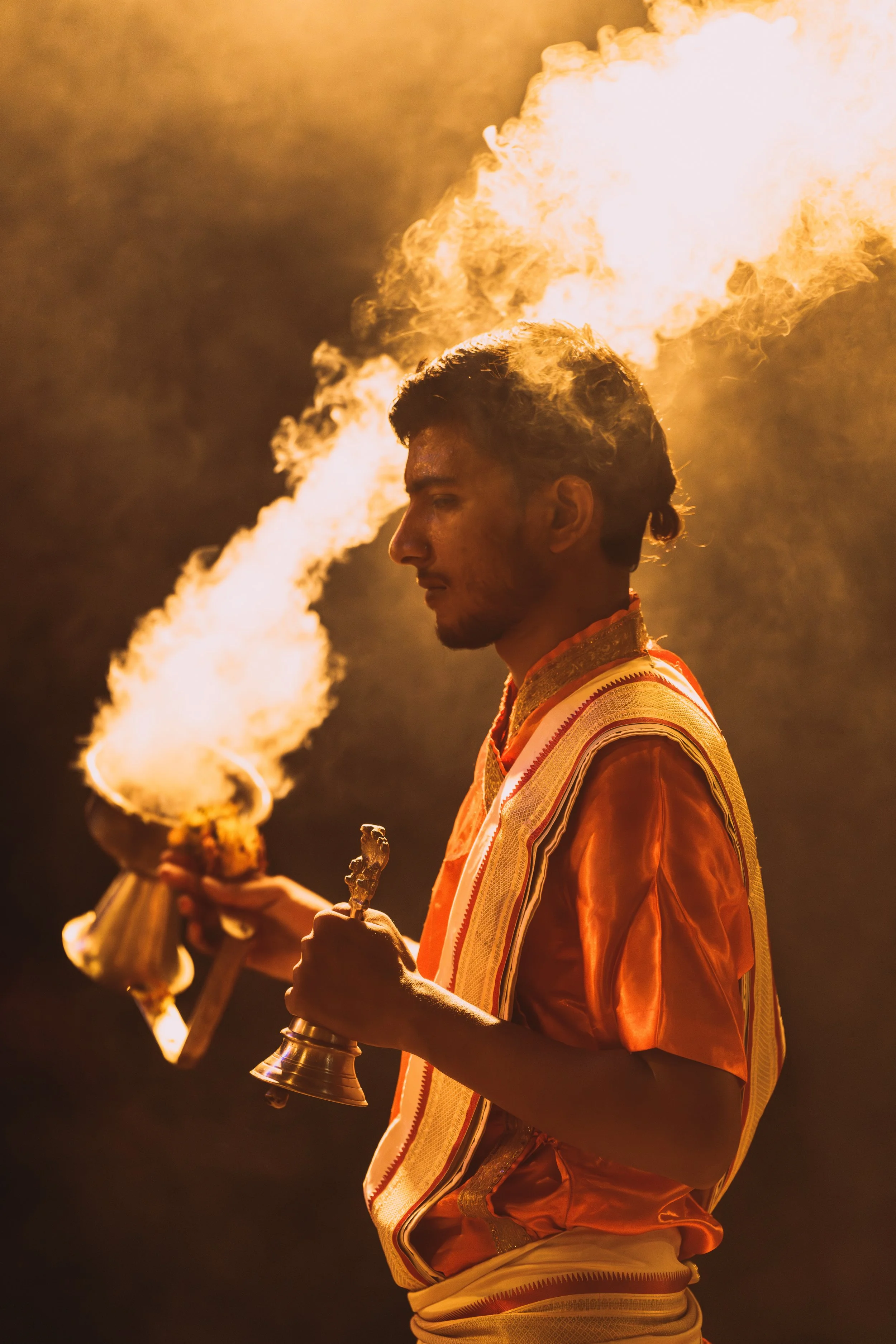 Prêtre hindou brandissant une lampe enflammée pendant la cérémonie Ganga Aarti à Varanasi