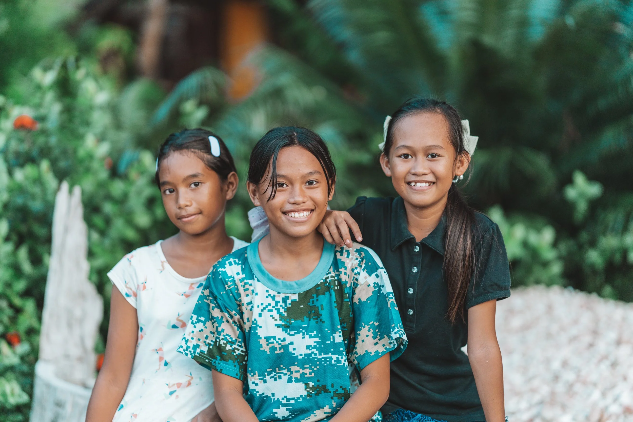 Trois jeunes filles souriantes du village de Culion aux Philippines