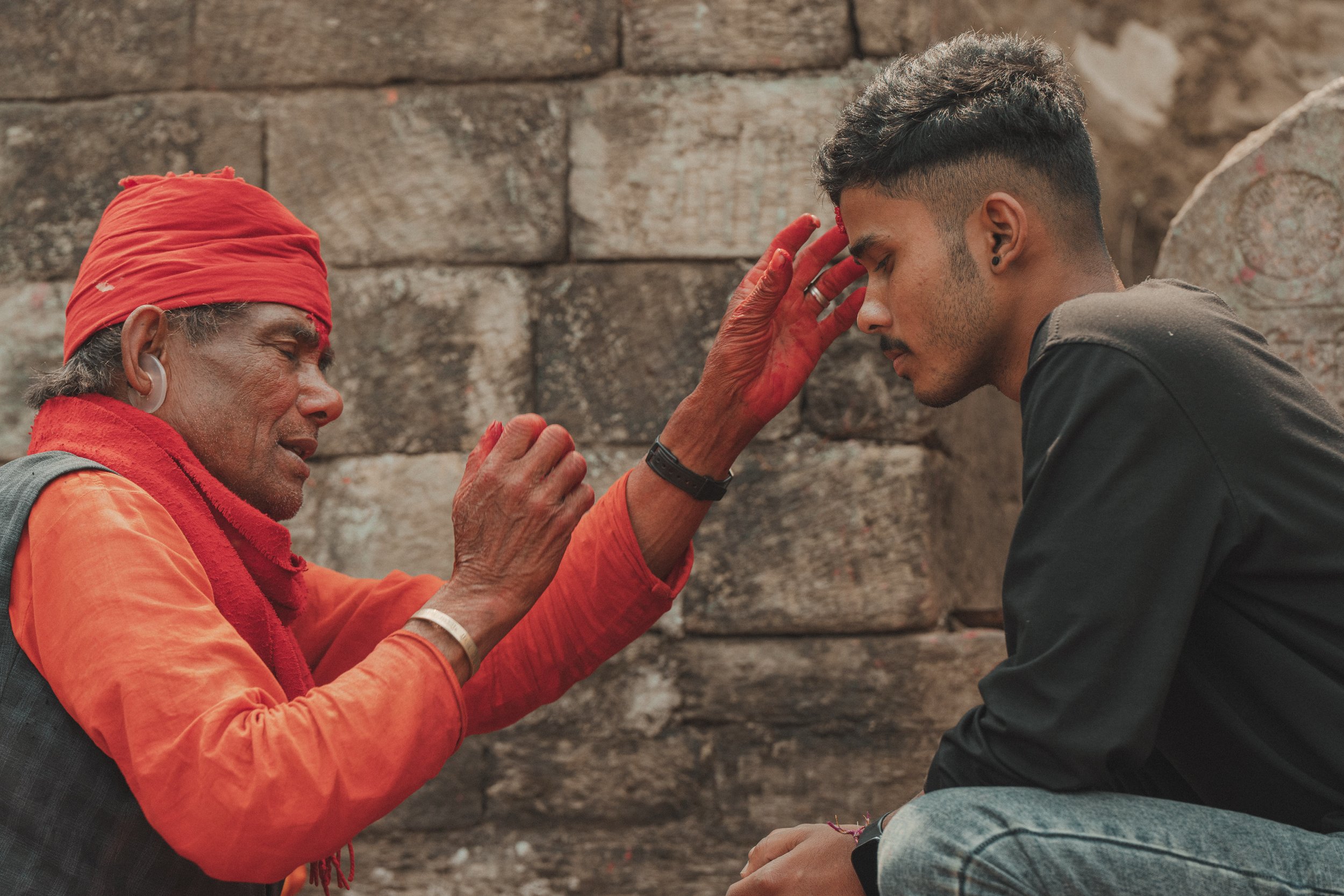 Prêtre hindou appliquant un tika sur le front d'un visiteur à Gorkha