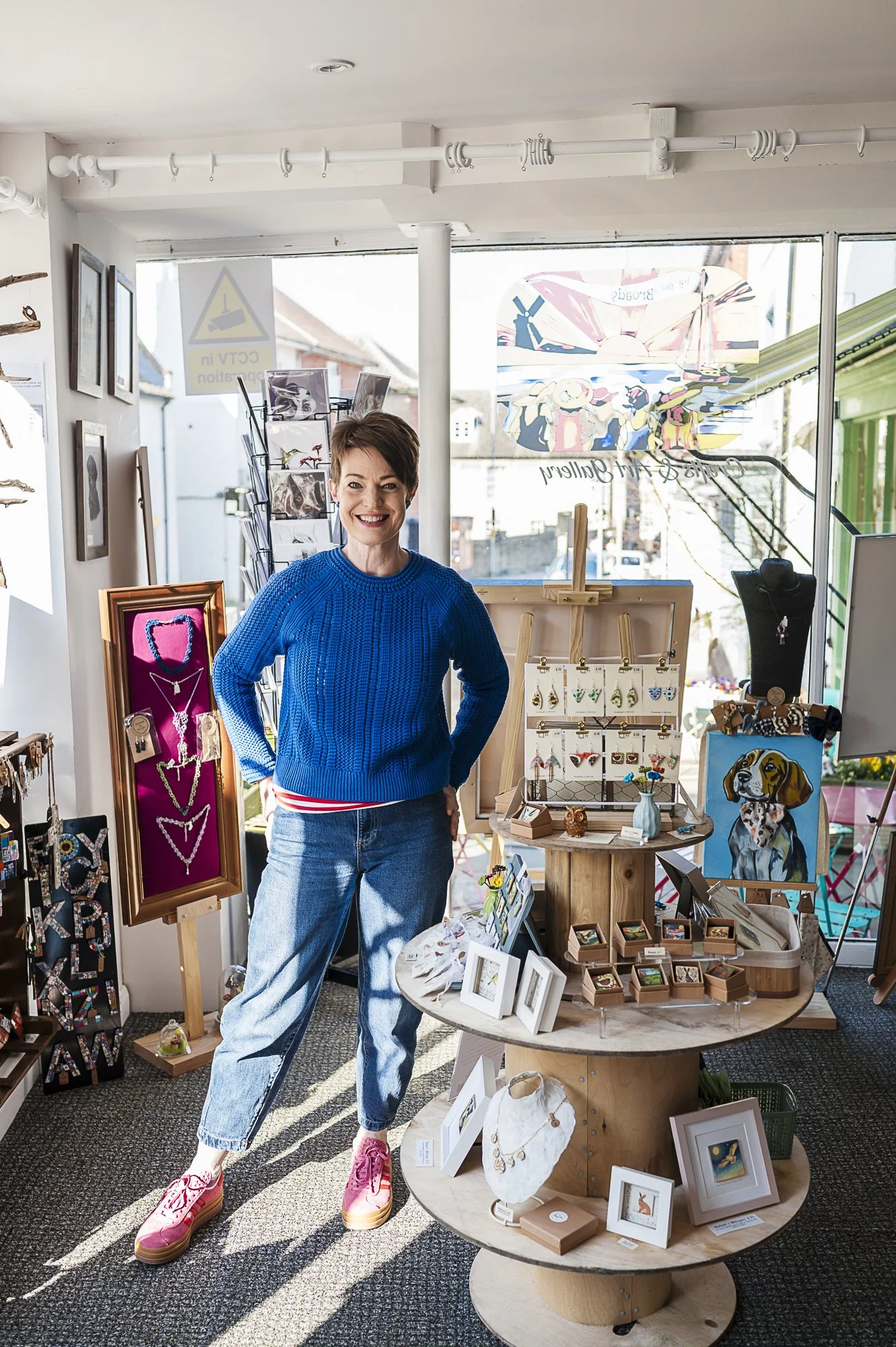 An artist standing beside her art