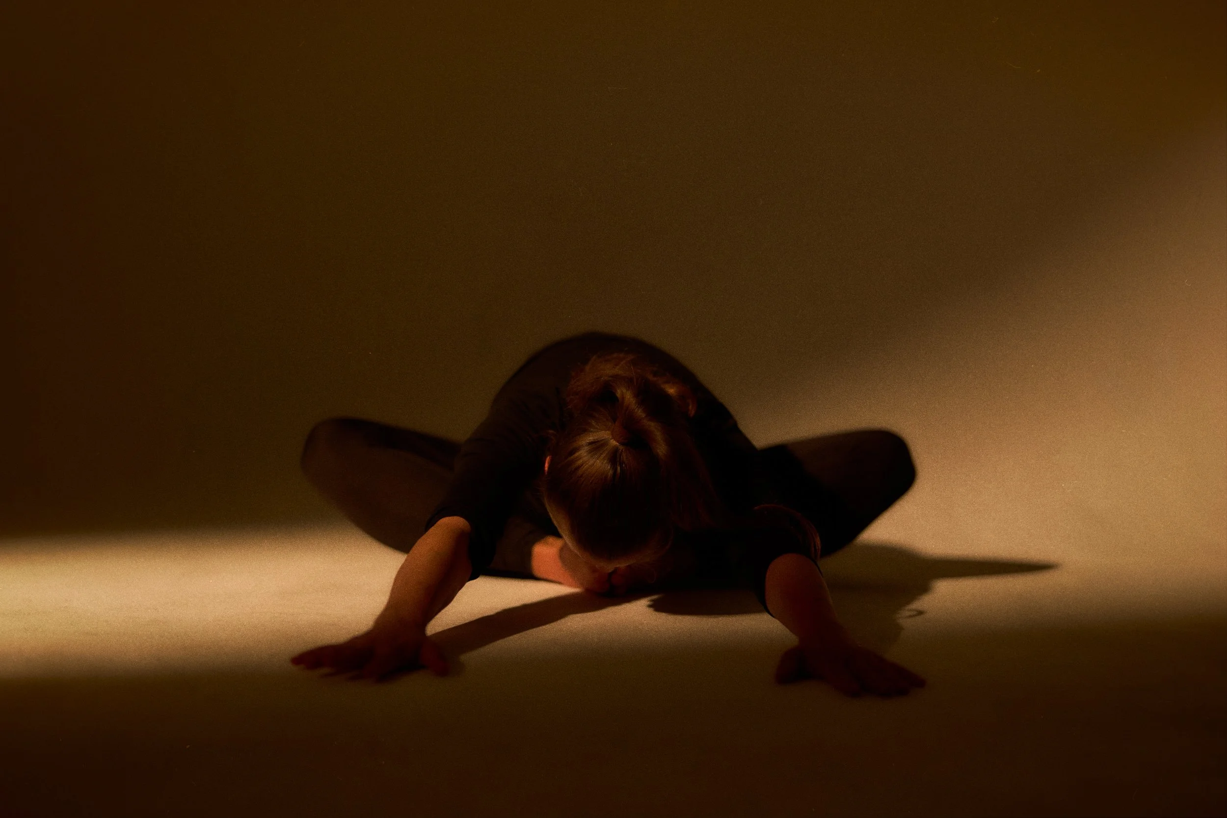 Yogalehrerin Lea bei KRUG12 in tiefer Ashtanga-Vorbeuge, warmes Licht im Studio.
