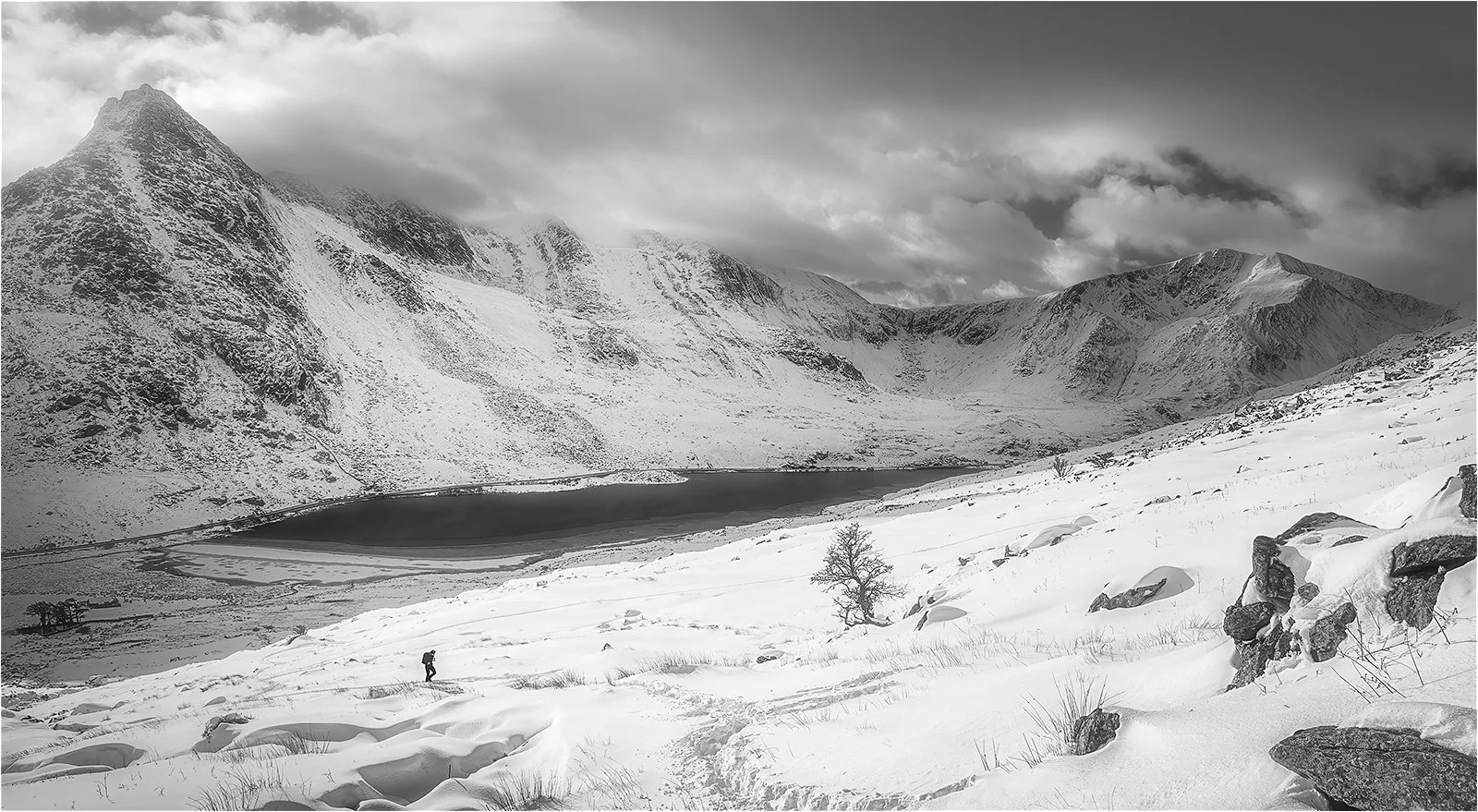 A winter scene in Snowdonia by Tryfan Eryri of a lone hiker in the snow
