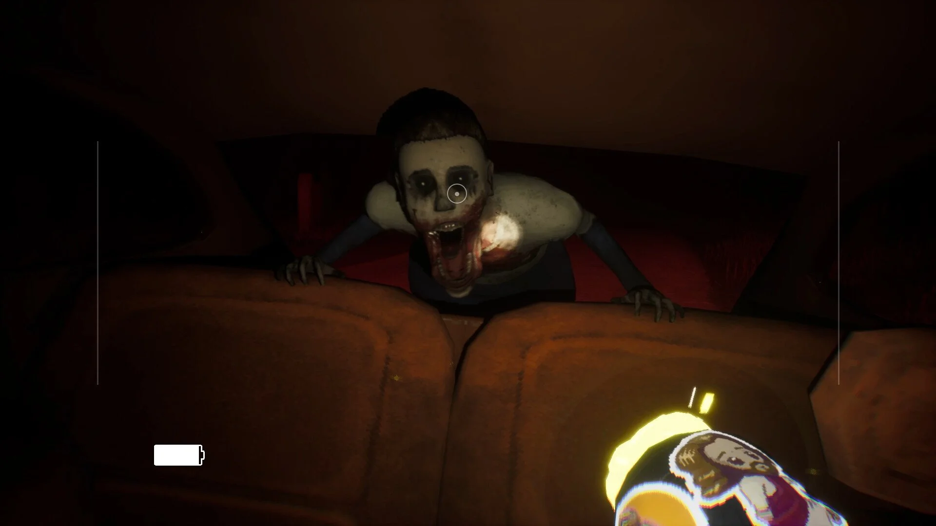 A person with their head and hands on a car's hood, with a terrifying, zombie-like face, wide-open mouth, and painted or distorted features, illuminated by the car's interior light at night.
