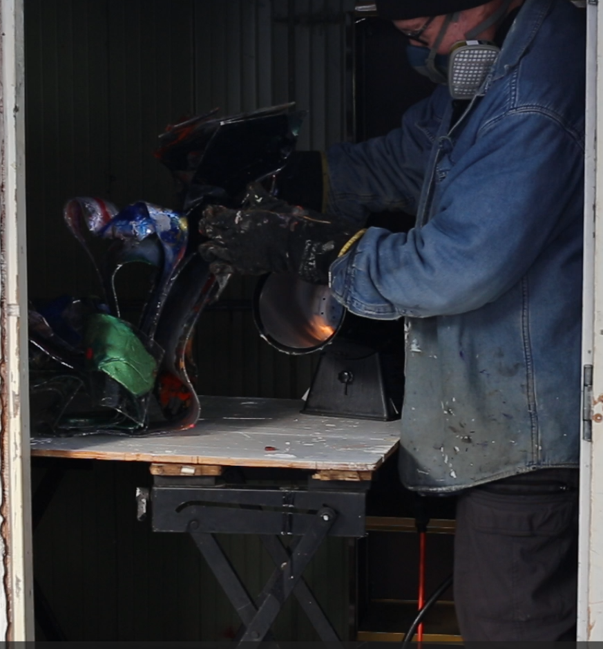 Mike Vandenberg, a Canadian contemporary artist, is working on a colorful, abstract sculpture in his outdoor studio during the winter.