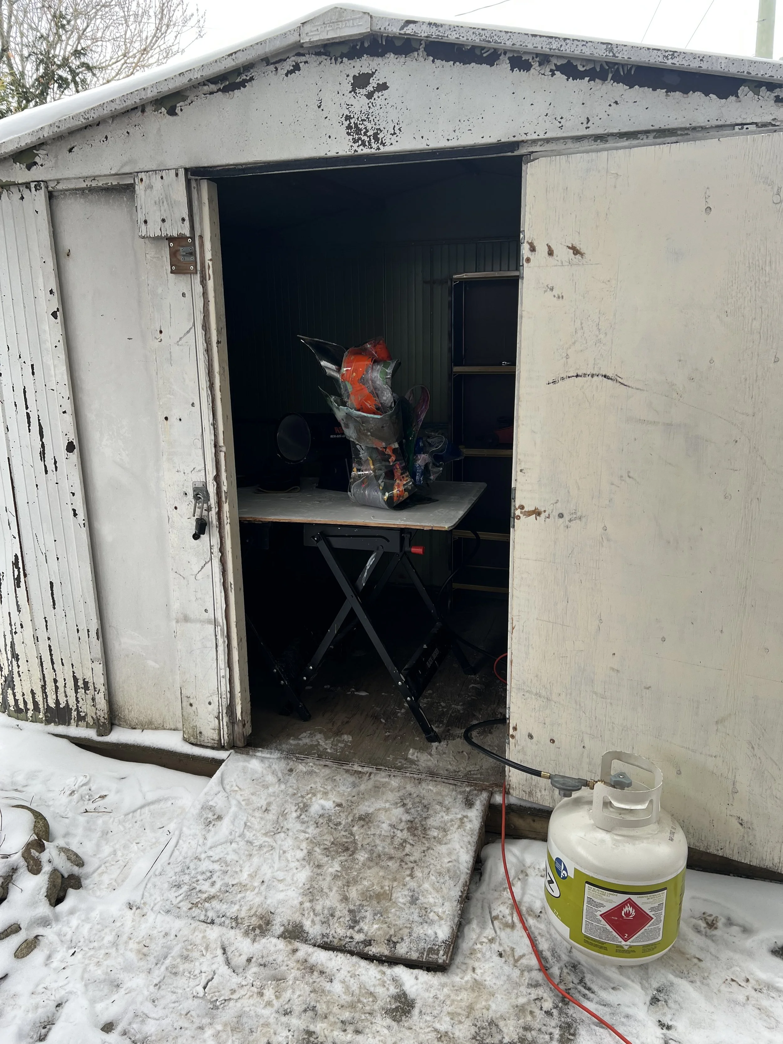 Mike Vandenberg, a Canadian contemporary artist, is working on a colorful, abstract sculpture in his outdoor studio during the winter.