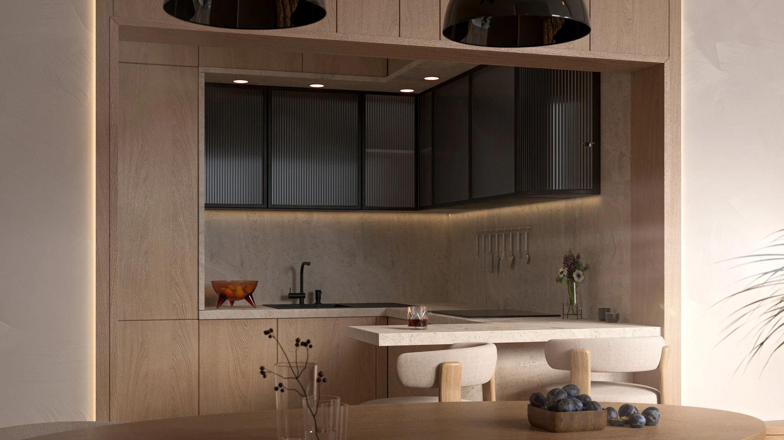 Luxus lakás modern konyhája világos fa alsó és fekete felső szekrényekkel, kis munkapulttal fekete mosogatóval, pohárral, virágvázzal és gyümölcstállal, bézs falakkal, előtérben fa étkezőasztallal.