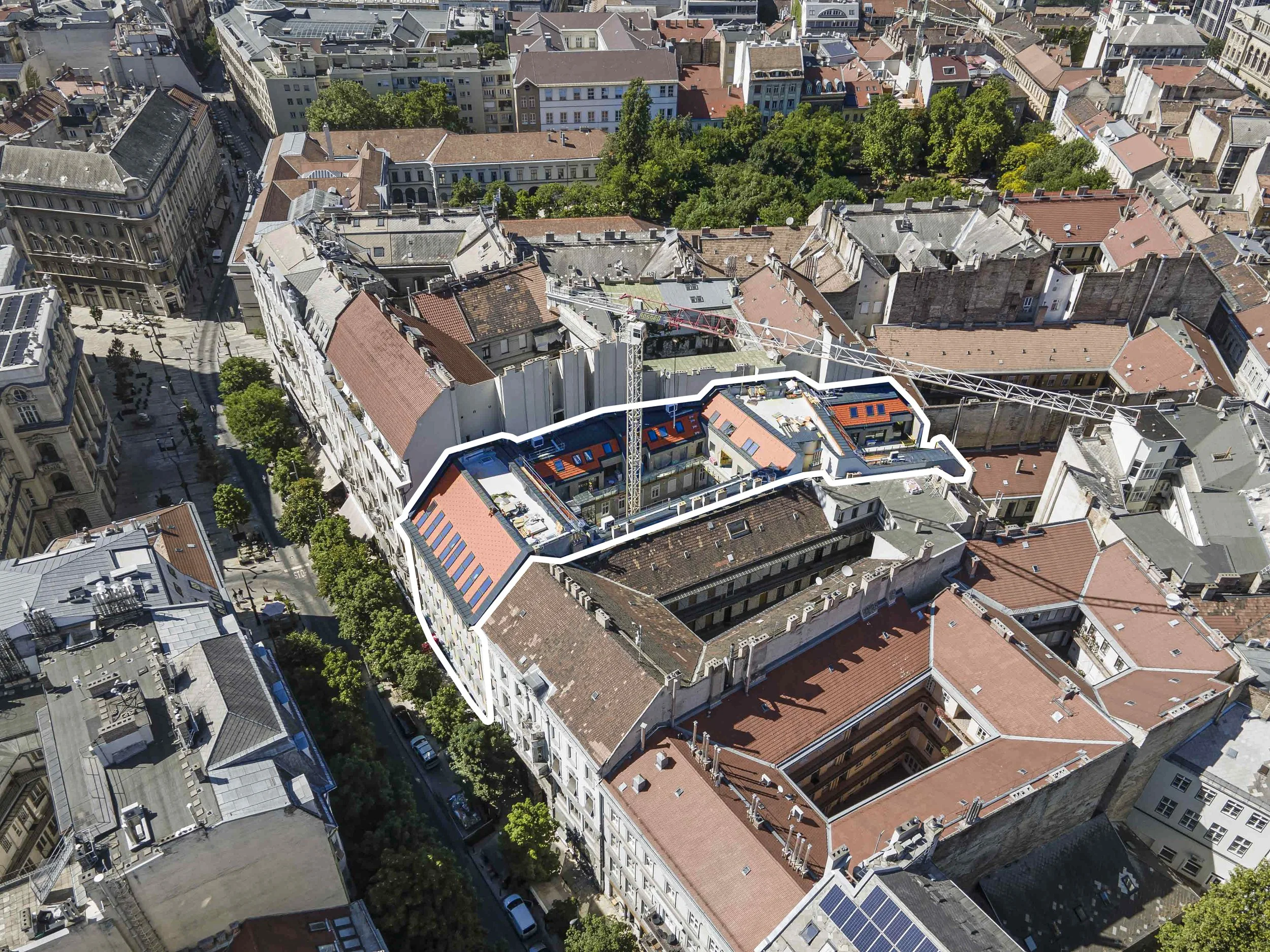 Drónfotó Budapest belvárosáról, melyen a Kecskeméti utca valamint a Károly kert tavaszi lombkoronái is látszanak. A belvárosi épületek közül fehér jelöléssel emelődik ki a K4Lofts építkezése.