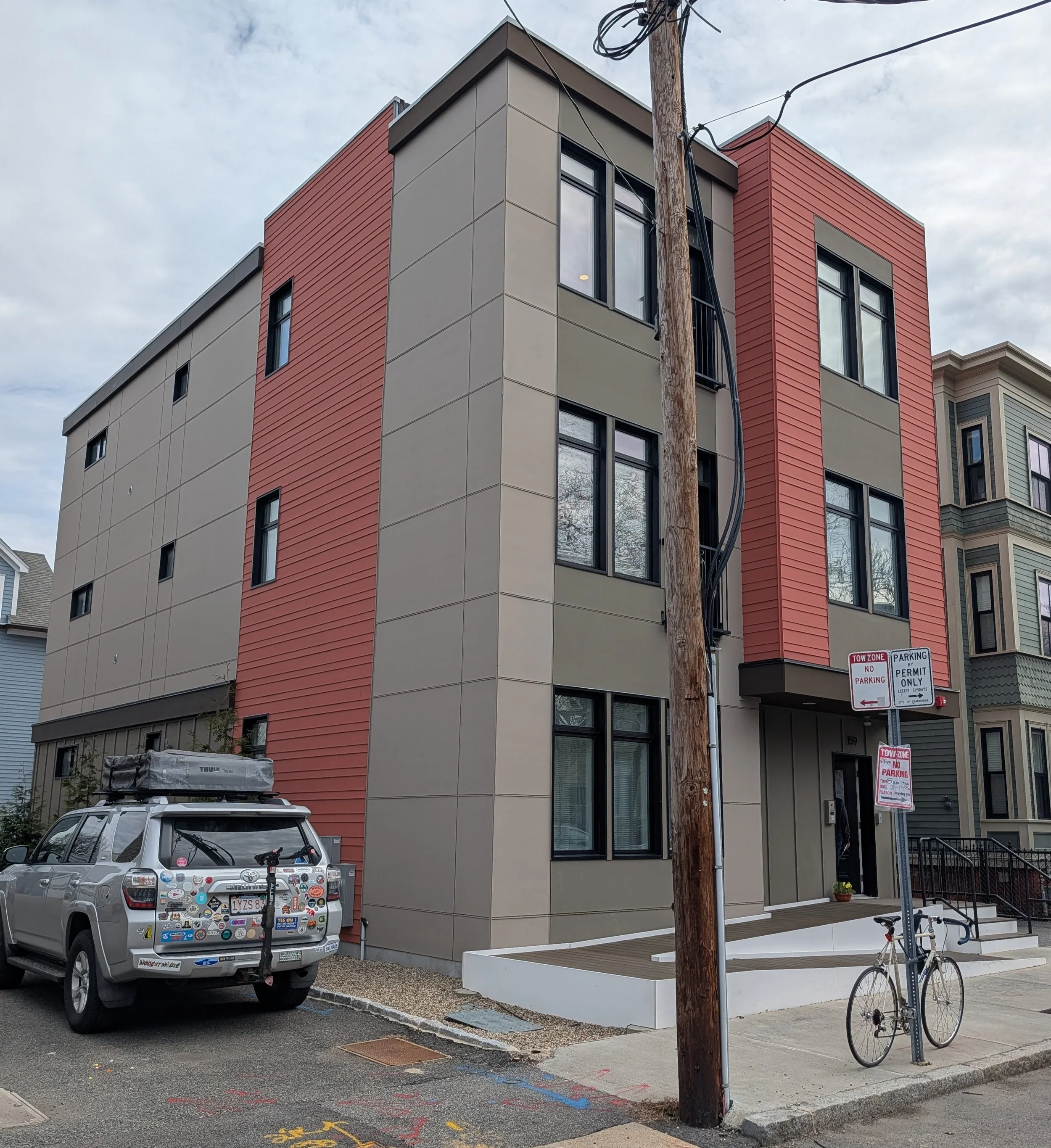 A light brown, rectangular, three-story building on a Cambridge Street