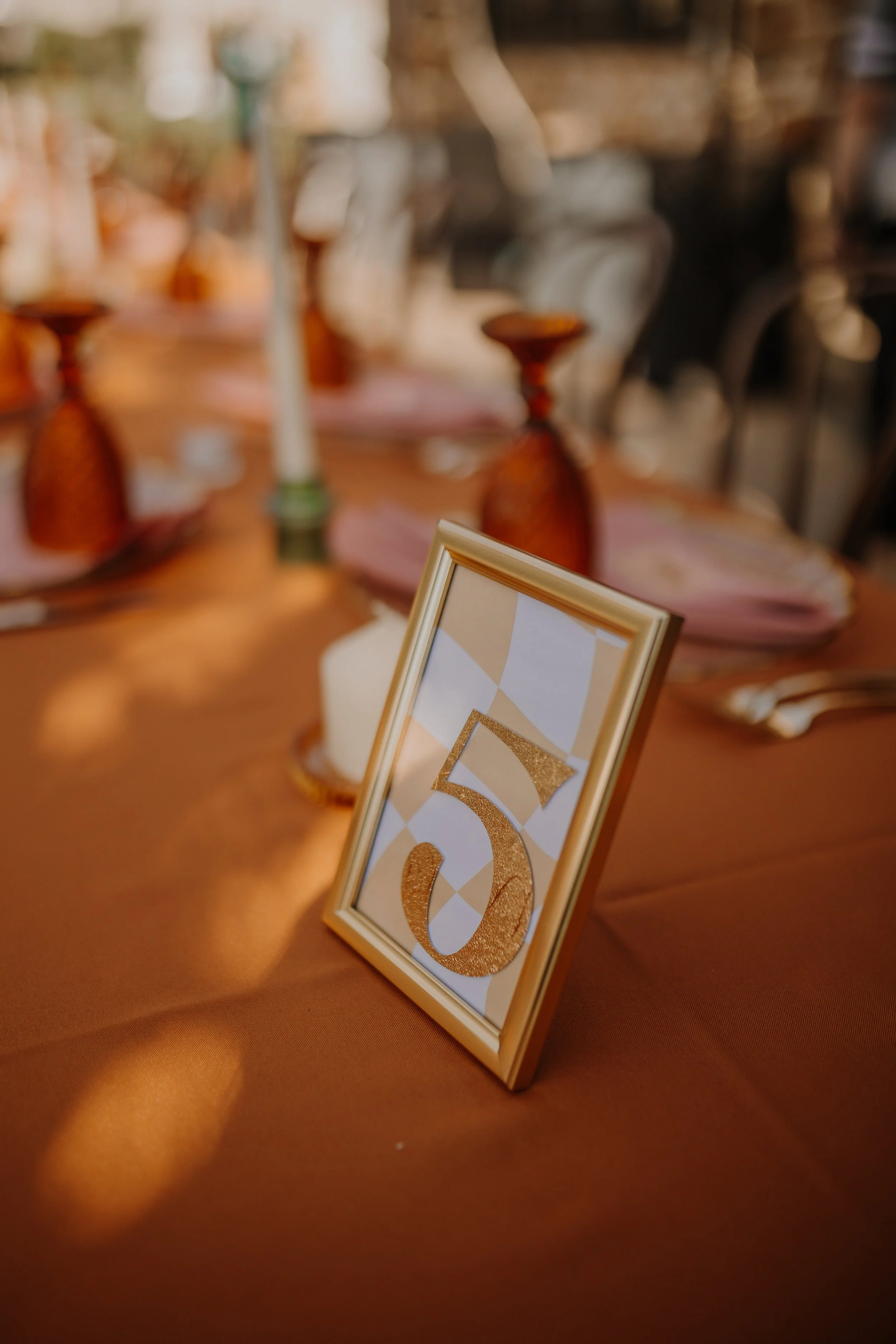Table number 5 sign on a decorated table at a formal event or celebration.
