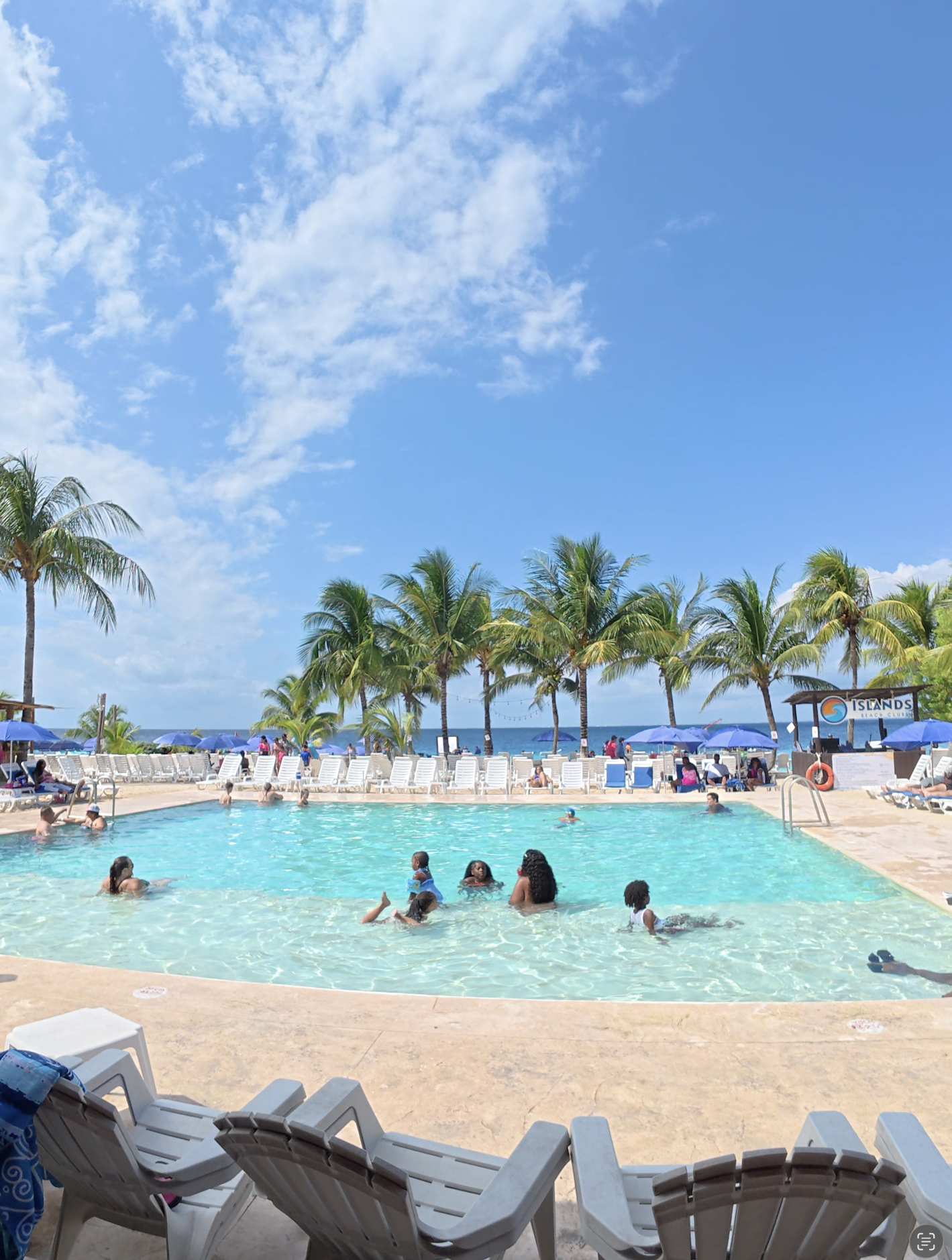 Main swimming pool and beach area at Islands Beach Club in Cozumel with lounge chairs and ocean views.